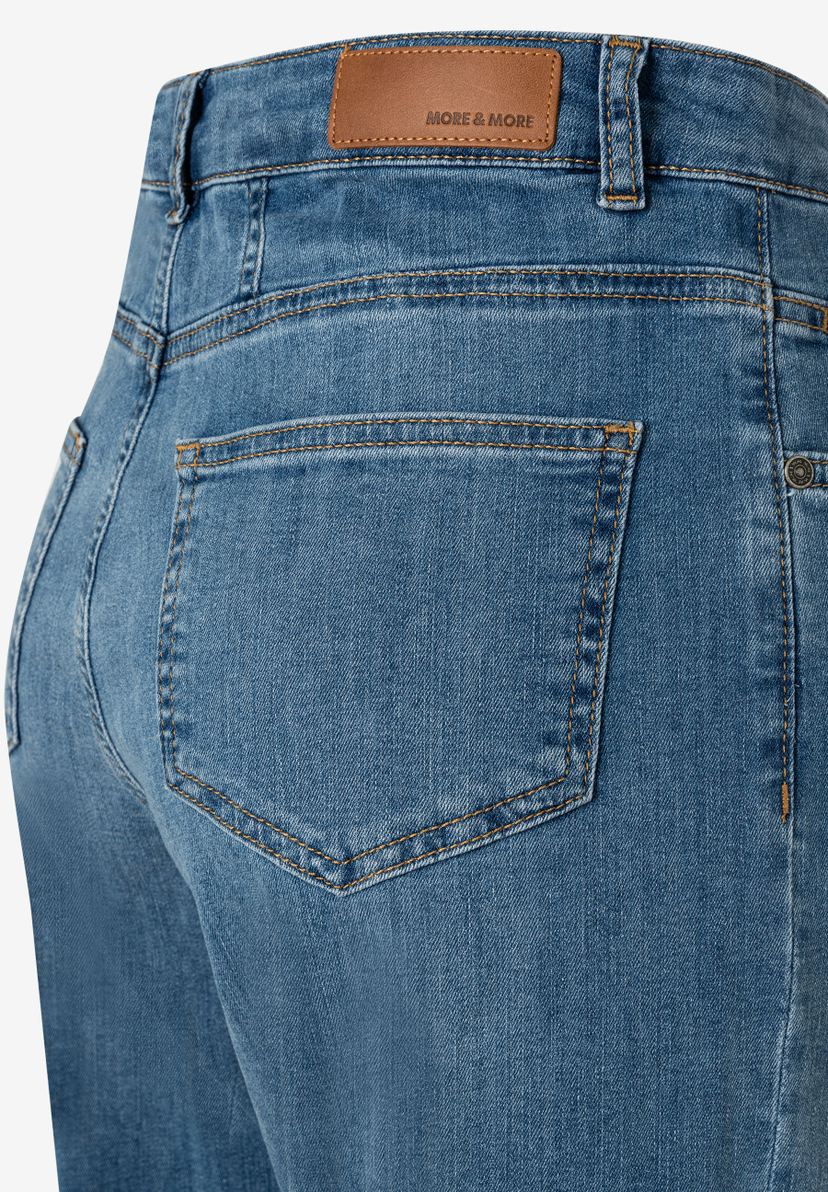 Nahaufnahme einer MORE & MORE Jeanshose aus Denim mit Gesäßtasche und Markenlabel. Nahaufnahme einer MORE & MORE Jeanshose aus Denim mit Gesäßtasche und Markenlabel.