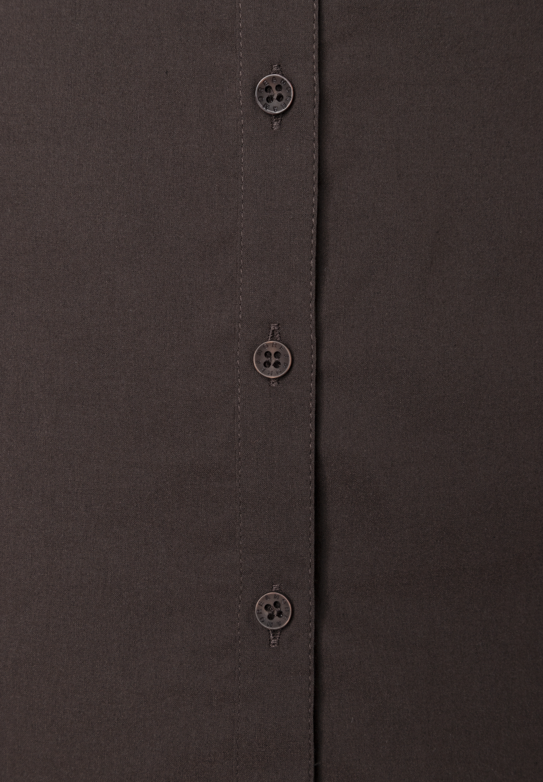 MORE & MORE Bluse: Nahaufnahme einer dunkelbraunen Bluse mit drei Knöpfen, die „MORE & MORE“ eingeprägt haben. MORE & MORE Bluse: Nahaufnahme einer dunkelbraunen Bluse mit drei Knöpfen, die „MORE & MORE“ eingeprägt haben.
