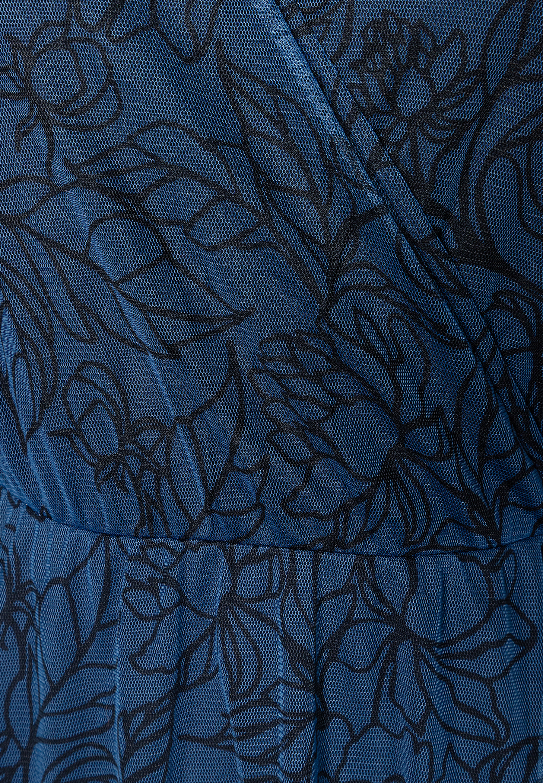 Nahaufnahme eines MORE & MORE Oberteils aus blauem Mesh mit floralem Muster. Nahaufnahme eines MORE & MORE Oberteils aus blauem Mesh mit floralem Muster.