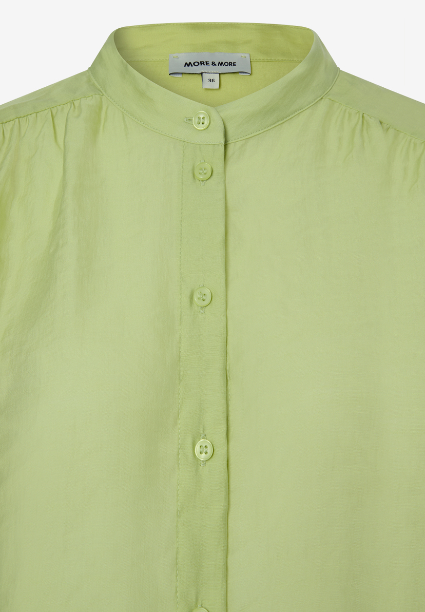 Detailaufnahme einer hellgrünen MORE & MORE Bluse mit Knopfleiste. Detailaufnahme einer hellgrünen MORE & MORE Bluse mit Knopfleiste.