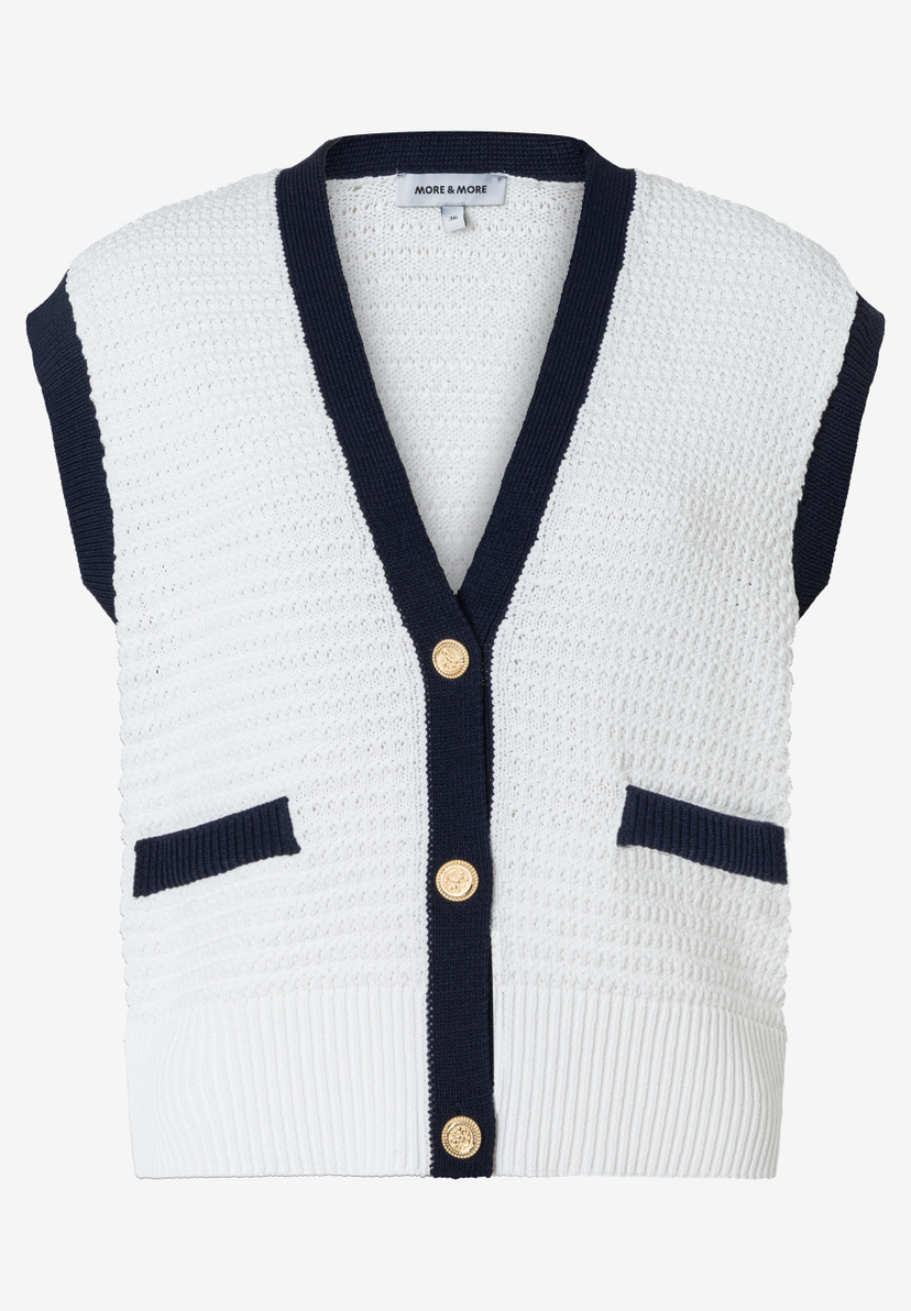 Ein ärmelloser Strick-Cardigan von MORE & MORE, weiß mit dunkelblauen Details und goldenen Knöpfen. Ein ärmelloser Strick-Cardigan von MORE & MORE, weiß mit dunkelblauen Details und goldenen Knöpfen.