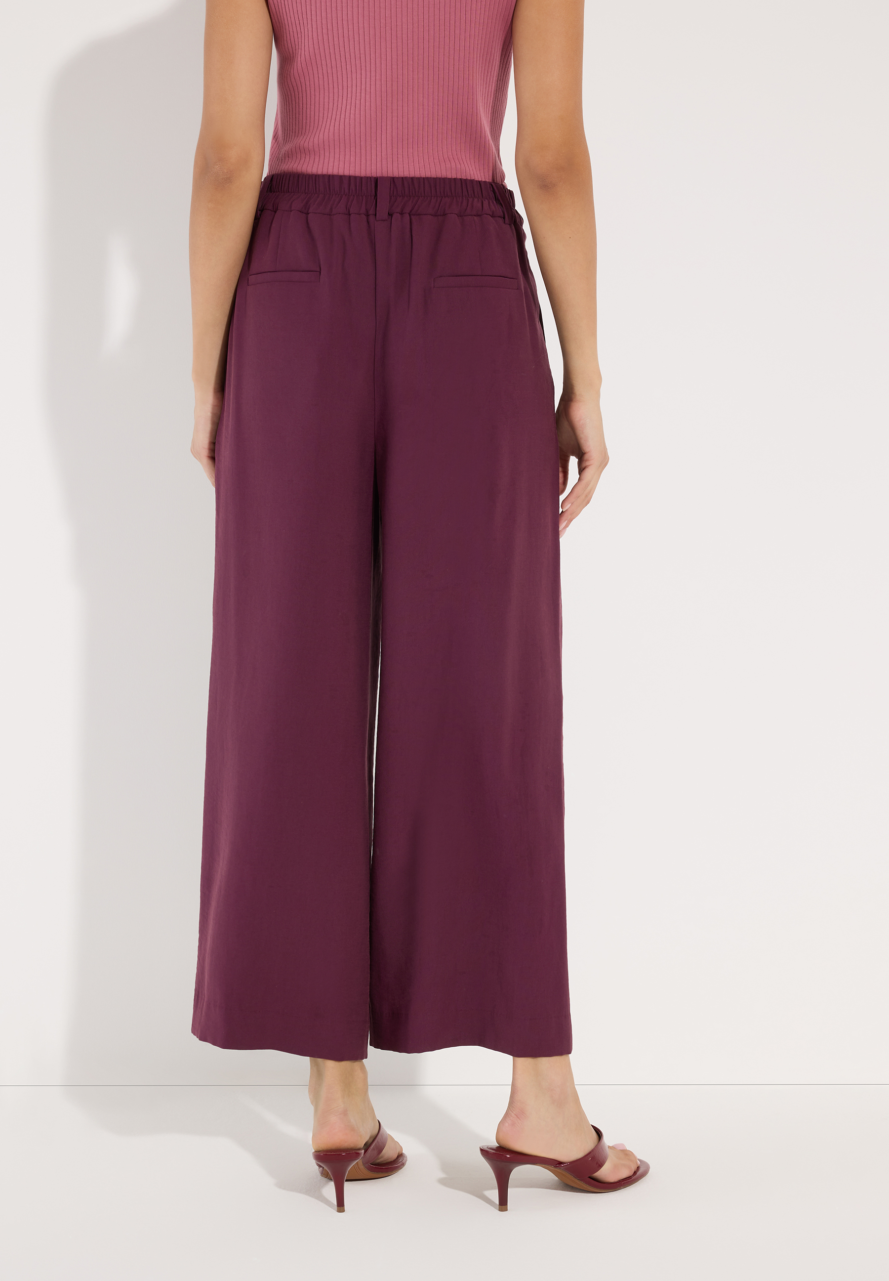 MORE & MORE Damenhose in Dunkelrot mit weitem Bein, hinten mit Gummizug und kleinen Taschen.