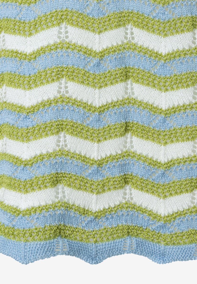 Nahaufnahme eines MORE & MORE Lochstrick-Pullovers mit Zickzackmuster in Weiß, Grün und Blau. Nahaufnahme eines MORE & MORE Lochstrick-Pullovers mit Zickzackmuster in Weiß, Grün und Blau.