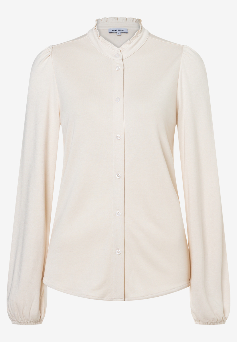 MORE & MORE Bluse: Eine cremefarbene Bluse mit Stehkragen und Rüschensaum sowie durchgehender Knopfleiste.