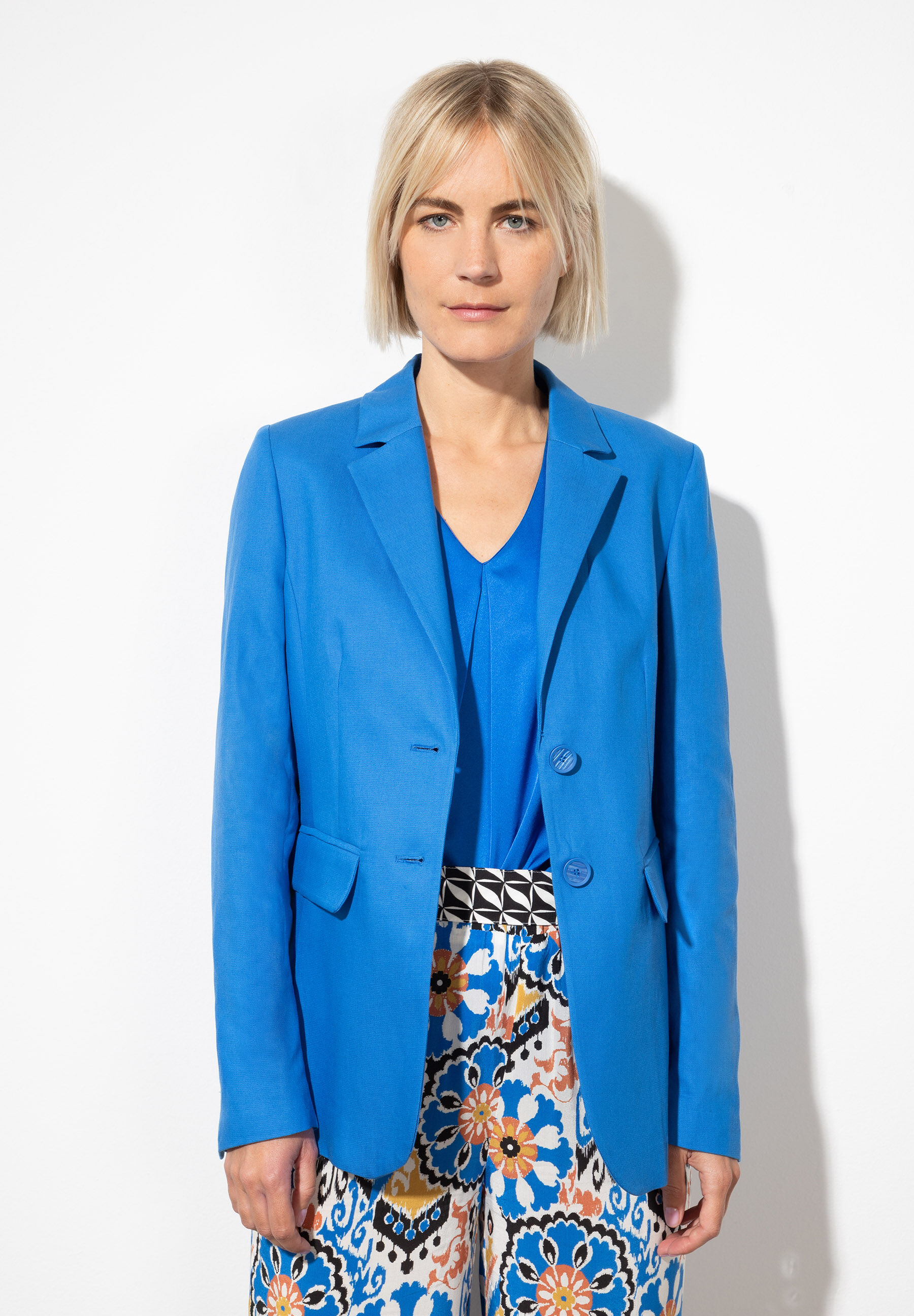 Eine Frau trägt einen blauen Blazer von MORE & MORE mit angenehmem Tragekomfort und Webware-Material. Eine Frau trägt einen blauen Blazer von MORE & MORE mit angenehmem Tragekomfort und Webware-Material.