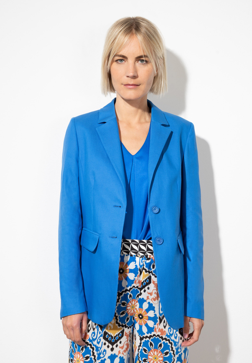 Eine Frau trägt einen blauen Blazer von MORE & MORE mit angenehmem Tragekomfort und Webware-Material. Eine Frau trägt einen blauen Blazer von MORE & MORE mit angenehmem Tragekomfort und Webware-Material.