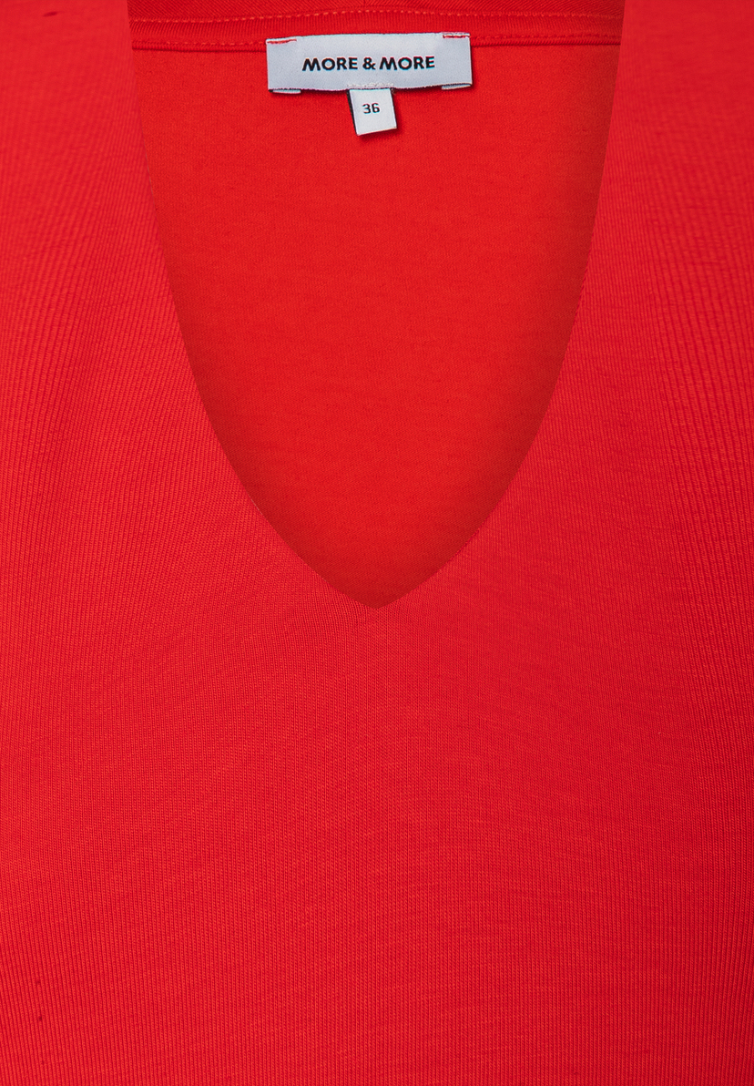 Nahaufnahme eines roten MORE & MORE Oberteils aus Jersey mit V-Ausschnitt. Größe 36. Nahaufnahme eines roten MORE & MORE Oberteils aus Jersey mit V-Ausschnitt. Größe 36.