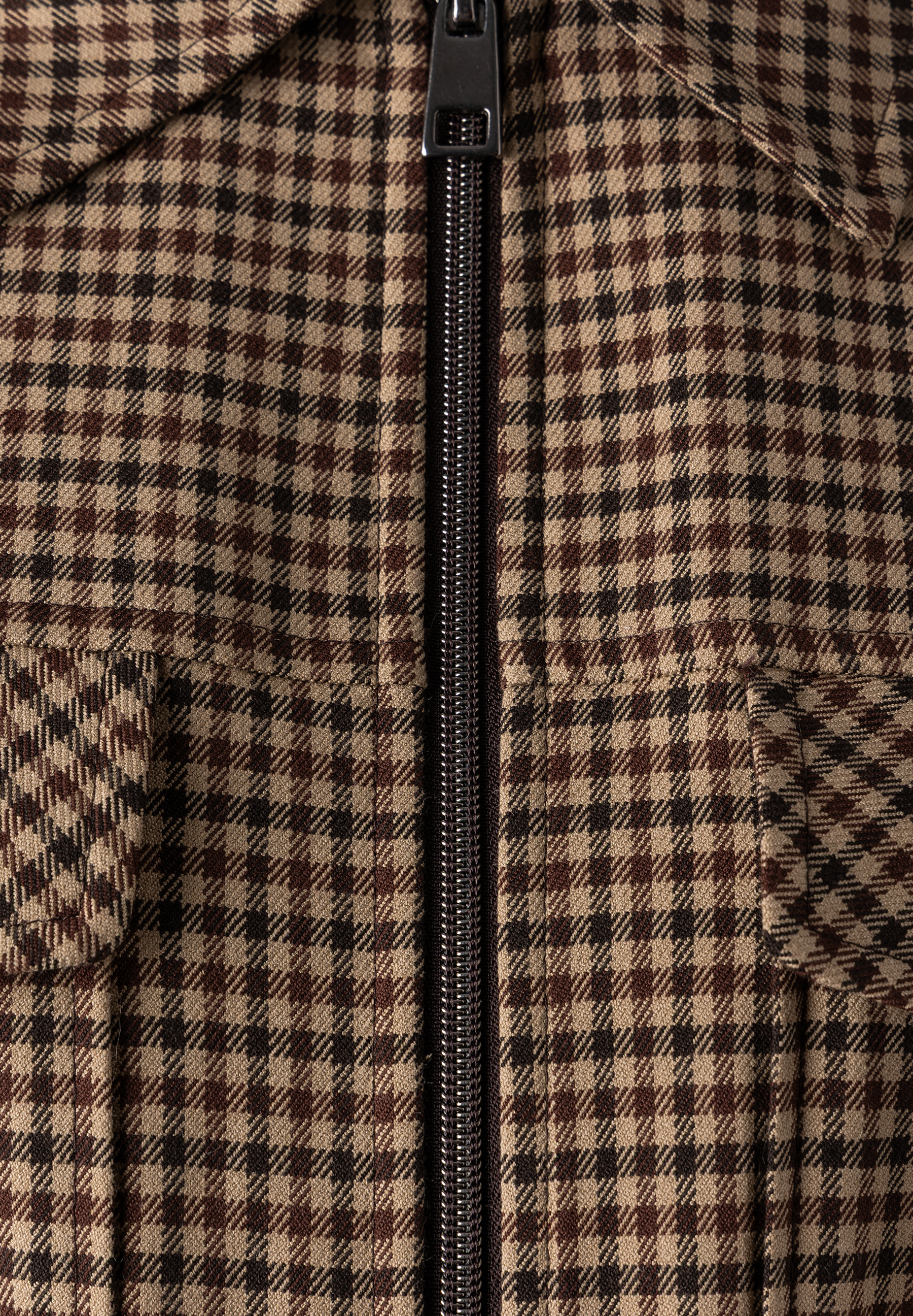 MORE & MORE Blazer mit beigefarbenem Hahnentrittmuster, schwarzem und braunem Karomuster und Reißverschluss, Nahaufnahme.