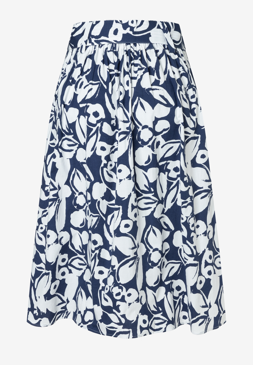 Ein ausgestellter Rock von MORE & MORE mit blau-weißem Blumenmuster vor einem hellen Hintergrund. Ein ausgestellter Rock von MORE & MORE mit blau-weißem Blumenmuster vor einem hellen Hintergrund.