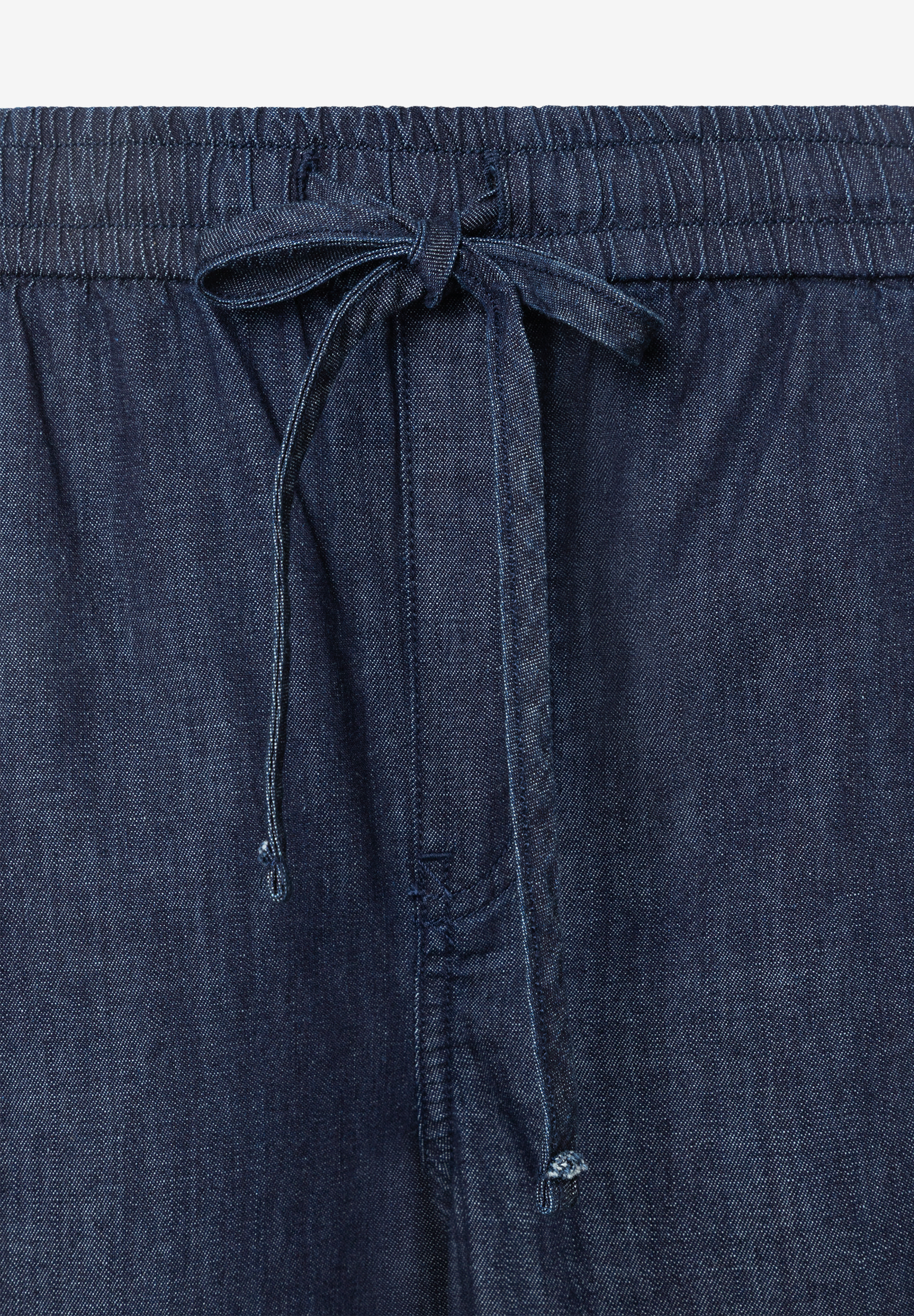 Detailaufnahme der MORE & MORE Denim-Hose mit Bund und Bindeband. Detailaufnahme der MORE & MORE Denim-Hose mit Bund und Bindeband.