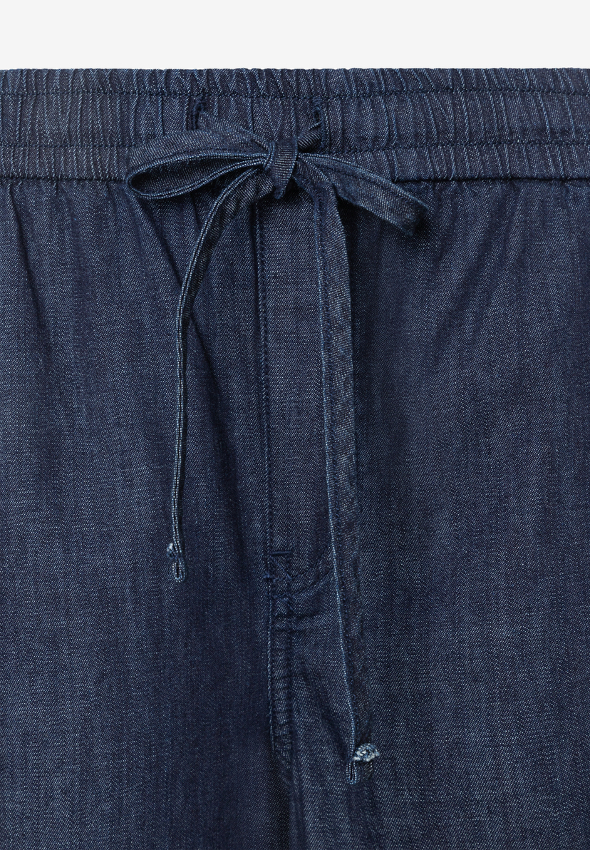 Detailaufnahme der MORE & MORE Denim-Hose mit Bund und Bindeband. Detailaufnahme der MORE & MORE Denim-Hose mit Bund und Bindeband.