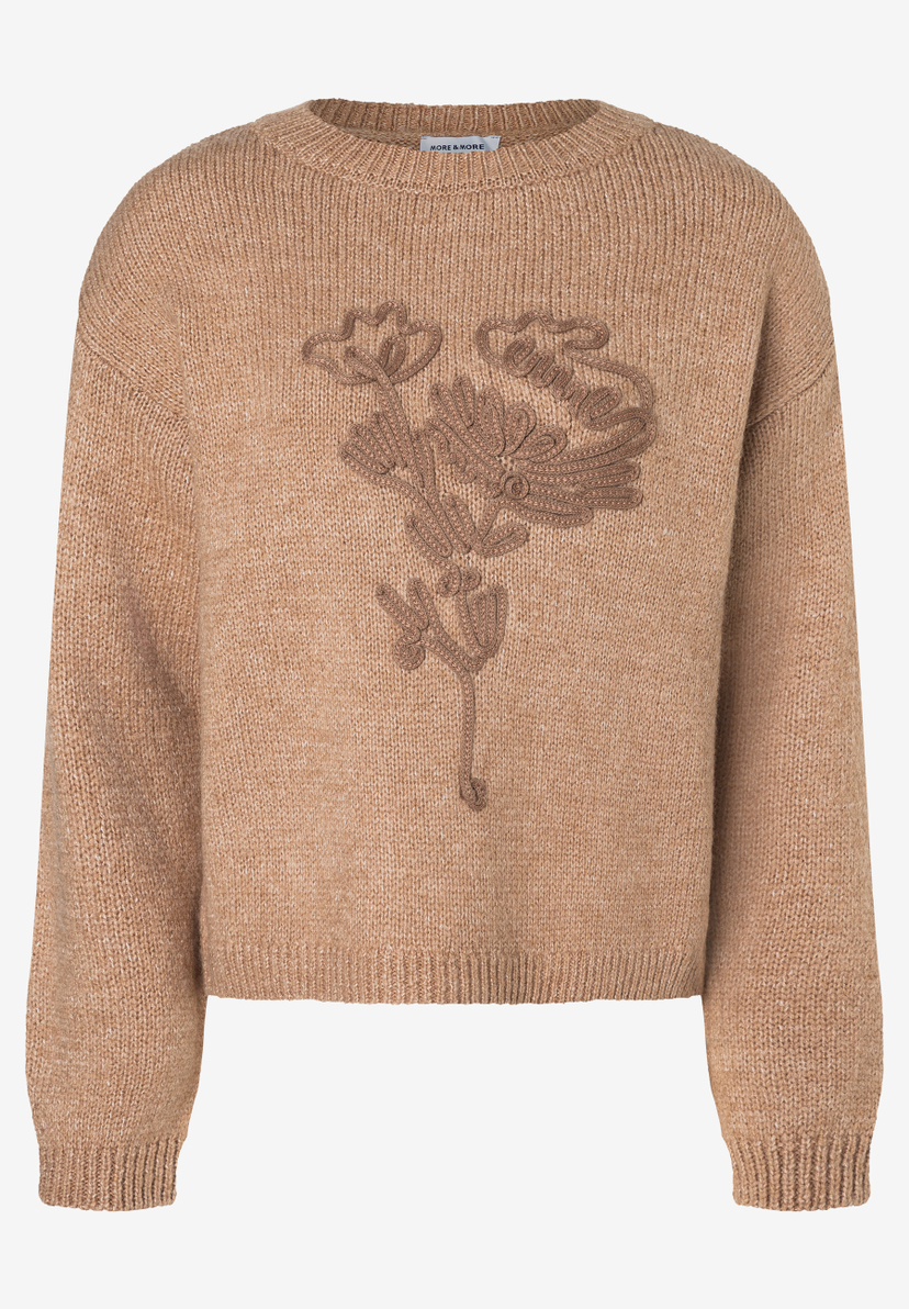 Ein beiger MORE & MORE Strickpullover mit einem floralen Strickmuster auf der Vorderseite. Ein beiger MORE & MORE Strickpullover mit einem floralen Strickmuster auf der Vorderseite.