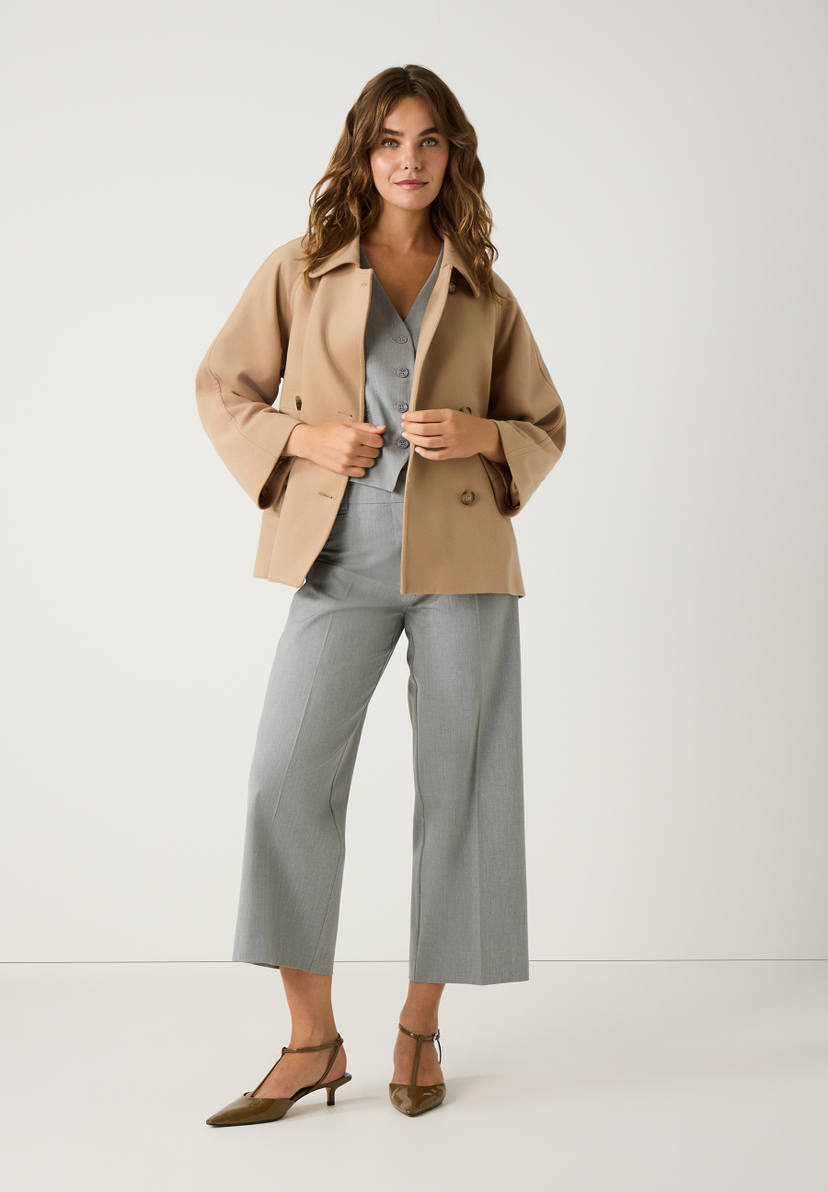 Eine Frau in MORE & MORE Hose und Jacke posiert vor einem weißen Hintergrund. Eine Frau in MORE & MORE Hose und Jacke posiert vor einem weißen Hintergrund.