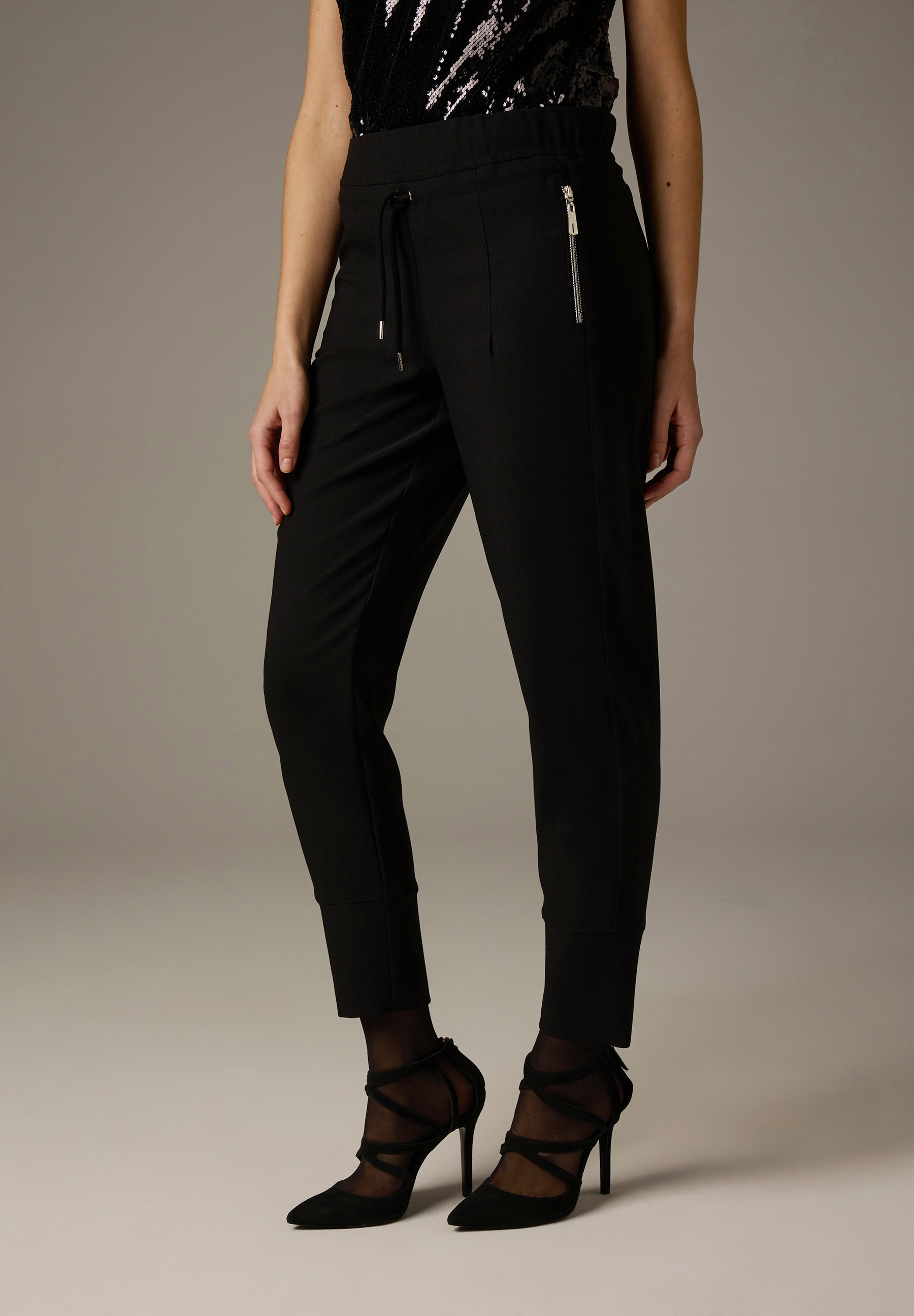 Schwarze MORE & MORE Hose mit Zippertasche und Schnürung. Dazu High Heels mit Riemchen. Schwarze MORE & MORE Hose mit Zippertasche und Schnürung. Dazu High Heels mit Riemchen.