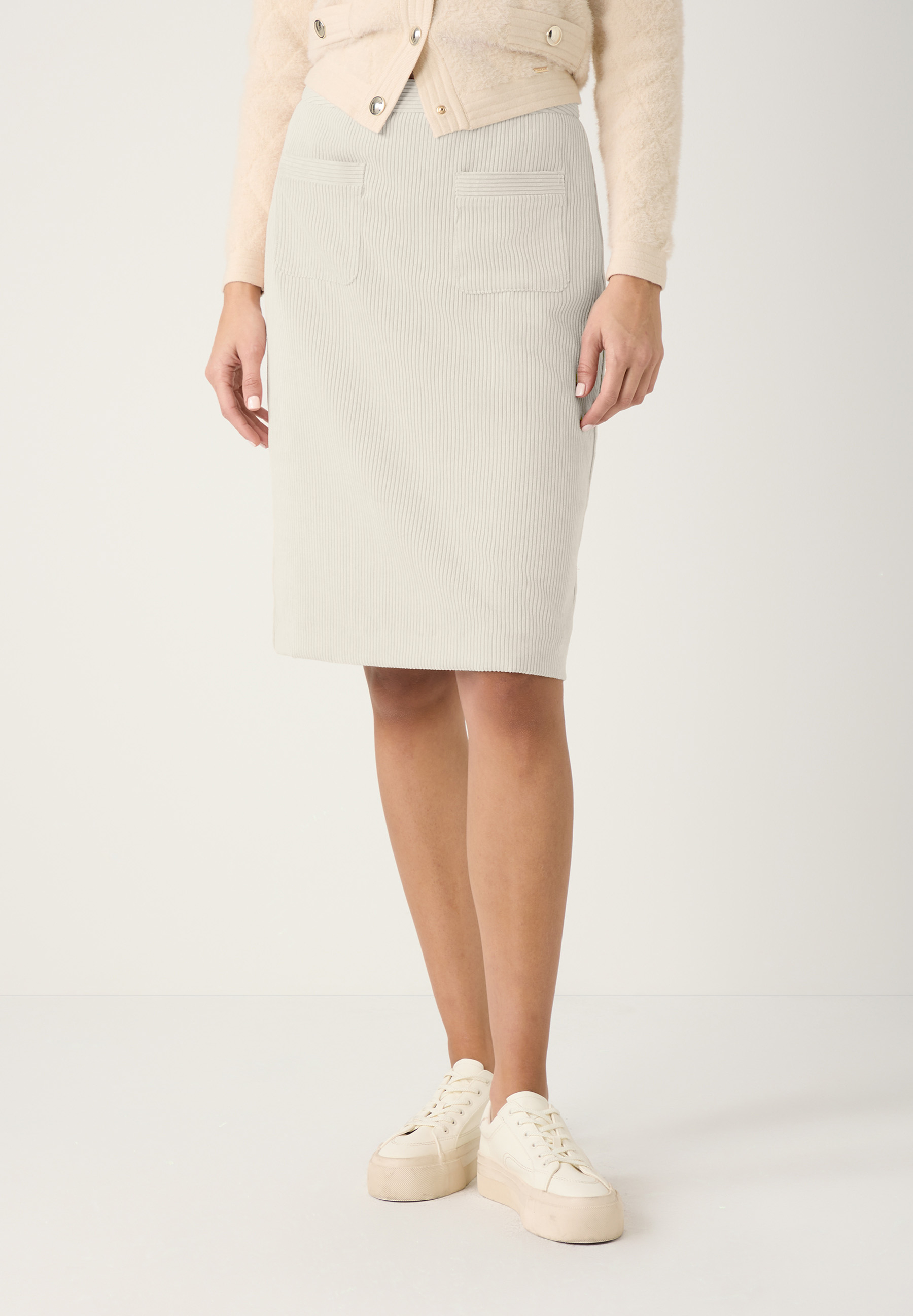 Ein beiger Cordrock von MORE & MORE mit elastischem Bund wird von einer Person getragen.
