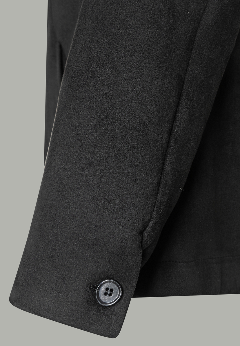 Nahaufnahme vom Ärmel eines schwarzen MORE & MORE Blazers mit Knopf. Nahaufnahme vom Ärmel eines schwarzen MORE & MORE Blazers mit Knopf.