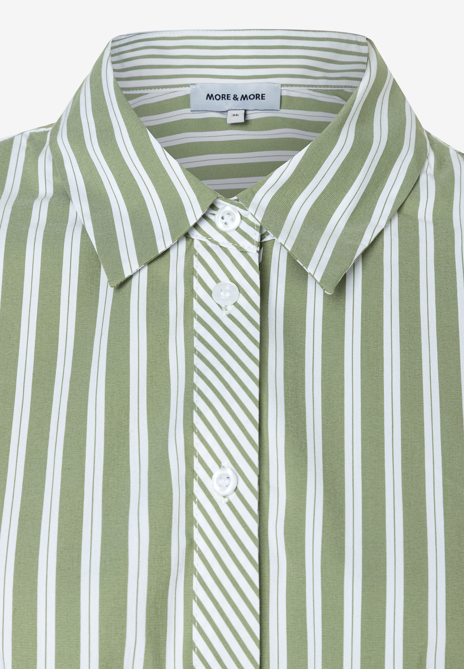 Nahaufnahme einer MORE & MORE Bluse. Das Oberteil ist grün-weiß gestreift und hat weiße Knöpfe. Nahaufnahme einer MORE & MORE Bluse. Das Oberteil ist grün-weiß gestreift und hat weiße Knöpfe.
