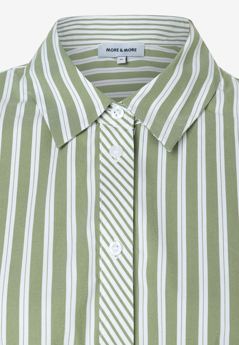 Nahaufnahme einer MORE & MORE Bluse. Das Oberteil ist grün-weiß gestreift und hat weiße Knöpfe. Nahaufnahme einer MORE & MORE Bluse. Das Oberteil ist grün-weiß gestreift und hat weiße Knöpfe.