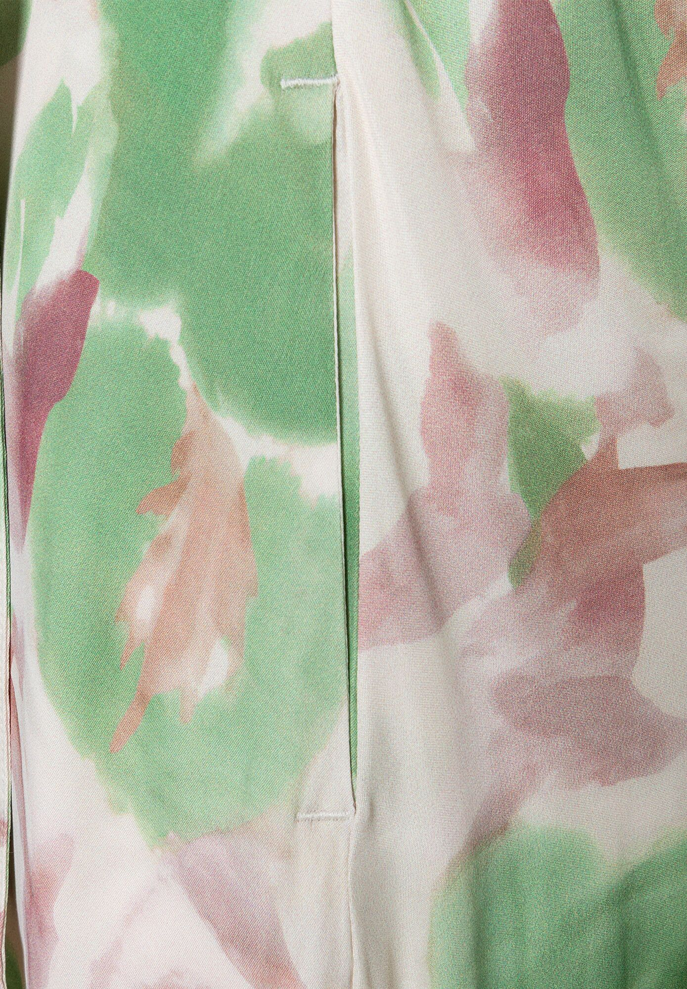 Nahaufnahme eines MORE & MORE Oberteils mit grün-rosa Muster und Viskose-Satin Konstruktion. Nahaufnahme eines MORE & MORE Oberteils mit grün-rosa Muster und Viskose-Satin Konstruktion.