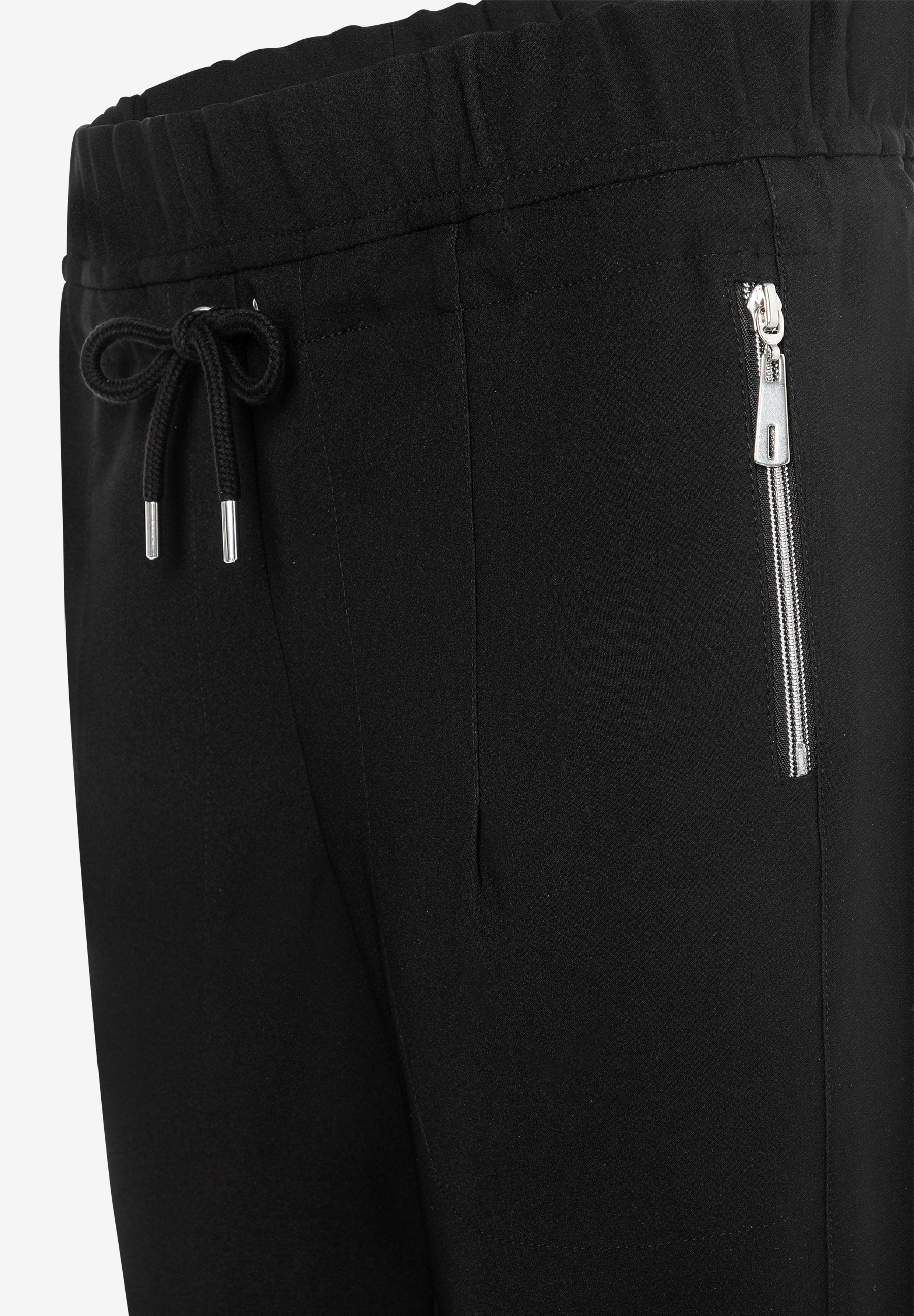 Detailaufnahme einer schwarzen Hose der Marke MORE & MORE mit silberfarbenem Reißverschluss an der Tasche und Kordelzug. Detailaufnahme einer schwarzen Hose der Marke MORE & MORE mit silberfarbenem Reißverschluss an der Tasche und Kordelzug.
