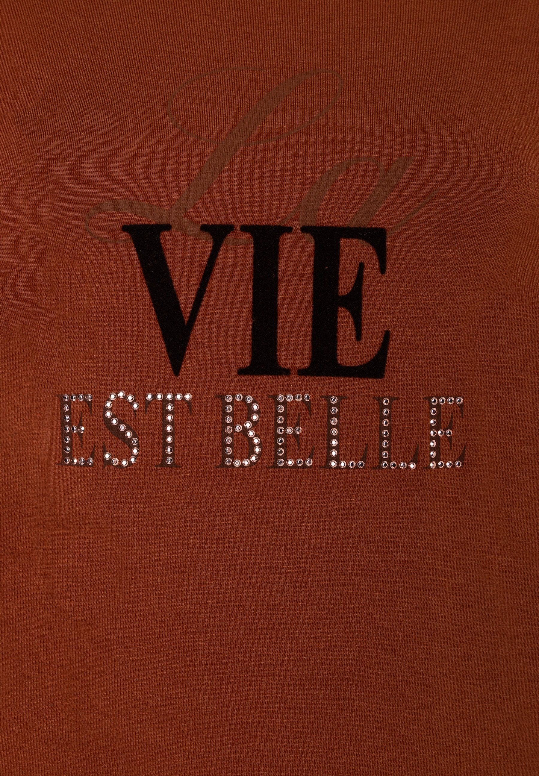 MORE & MORE T-Shirt in Rostrot mit Glitzeraufschrift "VIE EST BELLE" in Schwarz und Silber MORE & MORE T-Shirt in Rostrot mit Glitzeraufschrift "VIE EST BELLE" in Schwarz und Silber
