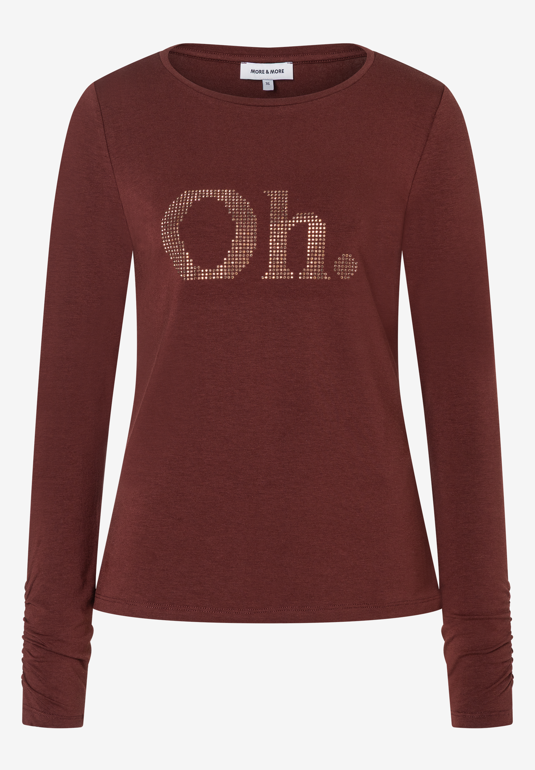 Ein Shirt von MORE & MORE in Rostrot mit langem Arm. Auf der Brust der Schriftzug "Oh." in goldenen Pailletten. Ein Shirt von MORE & MORE in Rostrot mit langem Arm. Auf der Brust der Schriftzug "Oh." in goldenen Pailletten.