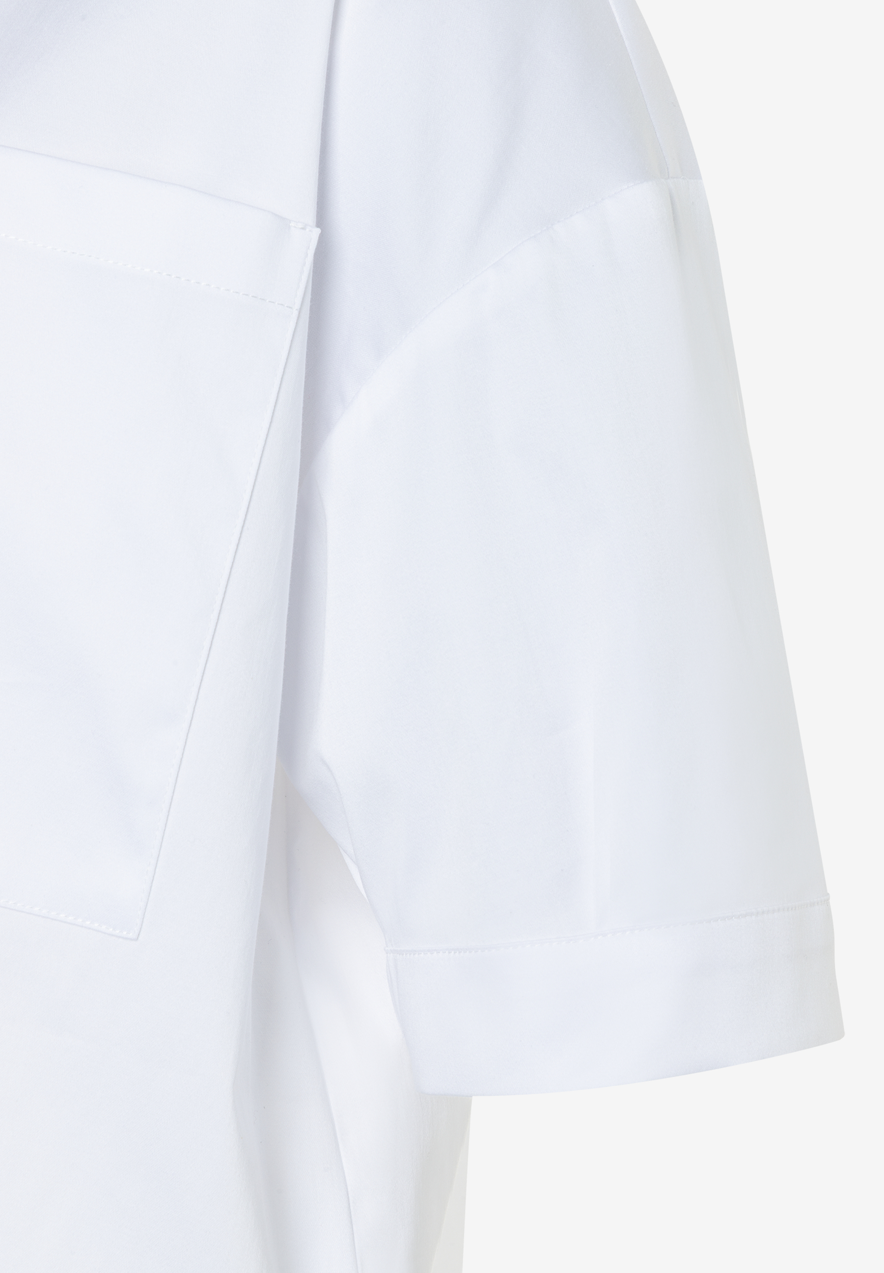 Detailaufnahme einer weißen MORE & MORE Bluse mit kurzer Ärmel und Brusttasche.