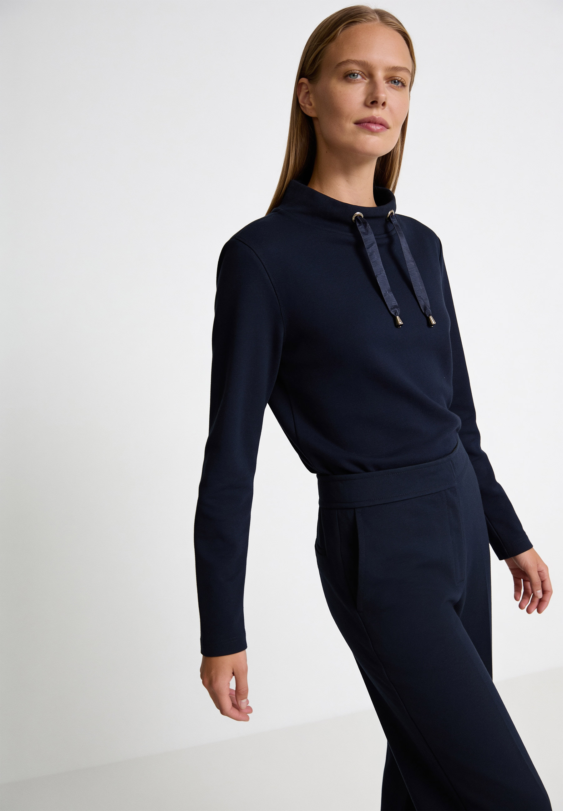 AI generated - MORE & MORE Damensweatshirt aus angenehmem, elastischem Sweatstoff in Marineblau. Die junge Frau trägt dazu passende Hose. AI generated - MORE & MORE Damensweatshirt aus angenehmem, elastischem Sweatstoff in Marineblau. Die junge Frau trägt dazu passende Hose.
