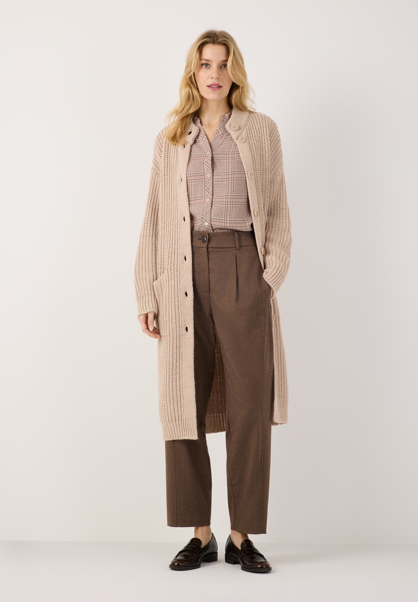 MORE & MORE Bluse: Blondes Model trägt eine gemusterte Bluse mit einem beigen langen Strickcardigan und brauner Hose. MORE & MORE Bluse: Blondes Model trägt eine gemusterte Bluse mit einem beigen langen Strickcardigan und brauner Hose.