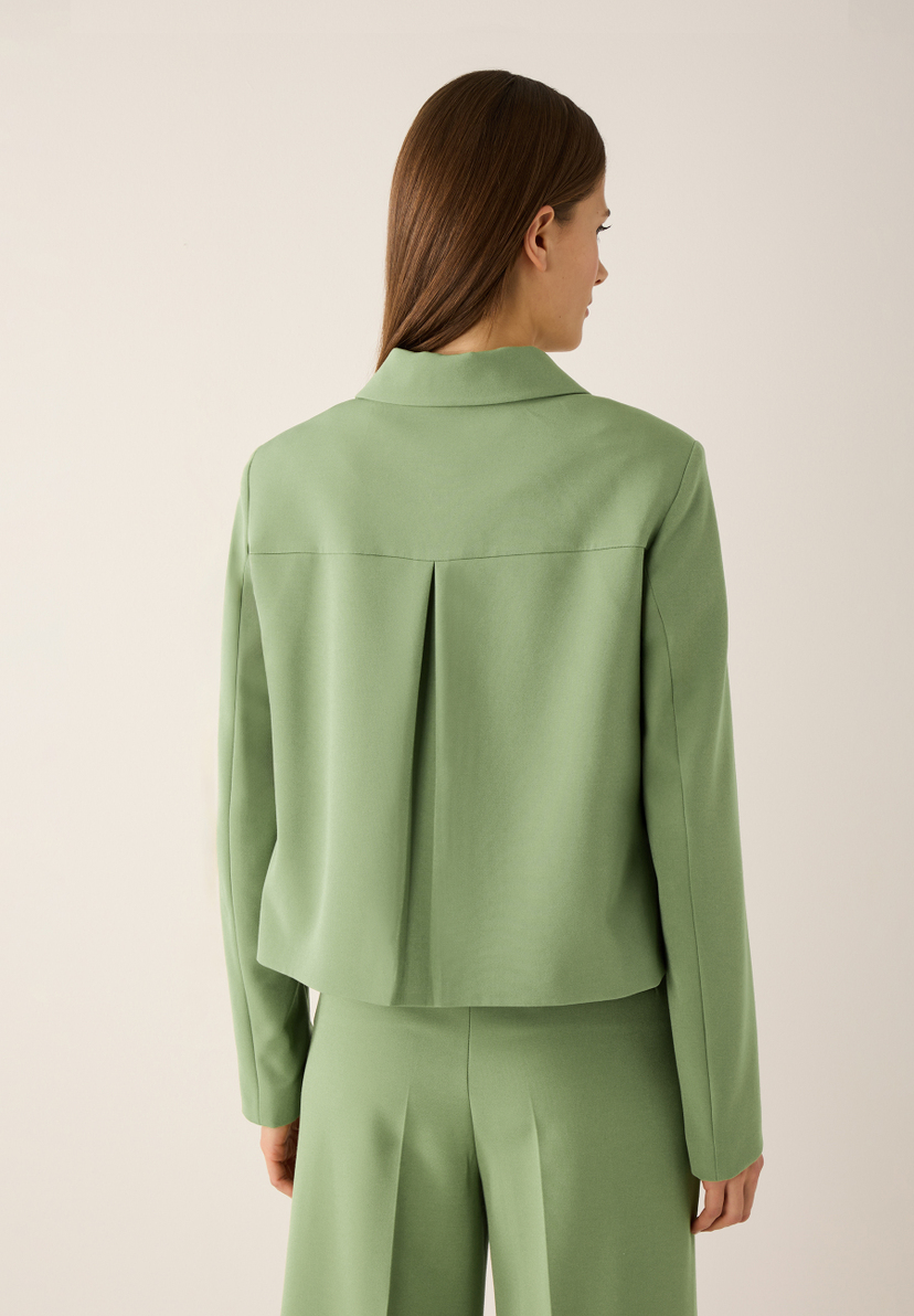 Eine Frau trägt einen grünen MORE & MORE Blazer mit Webware und elastischem Stoff. Eine Frau trägt einen grünen MORE & MORE Blazer mit Webware und elastischem Stoff.