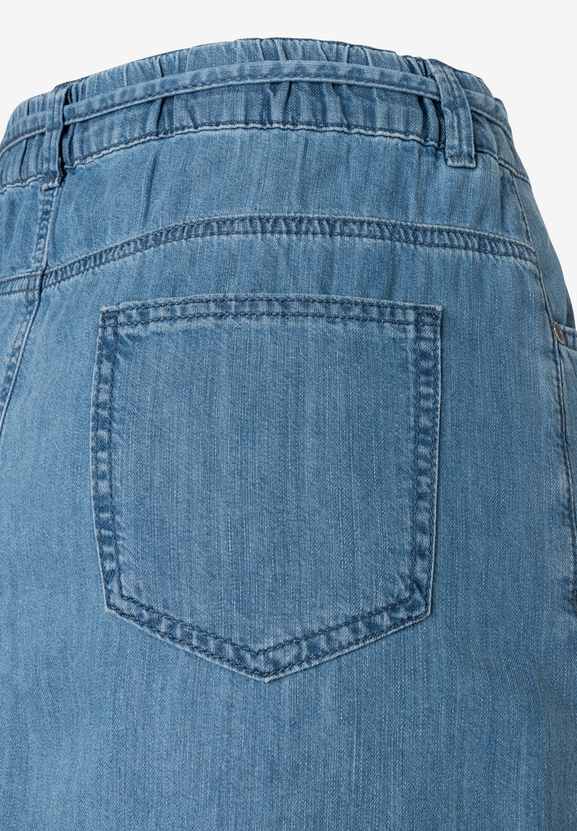 Detailansicht eines Jeansrocks von MORE & MORE mit Gummibund und aufgesetzter Gesäßtasche. Detailansicht eines Jeansrocks von MORE & MORE mit Gummibund und aufgesetzter Gesäßtasche.