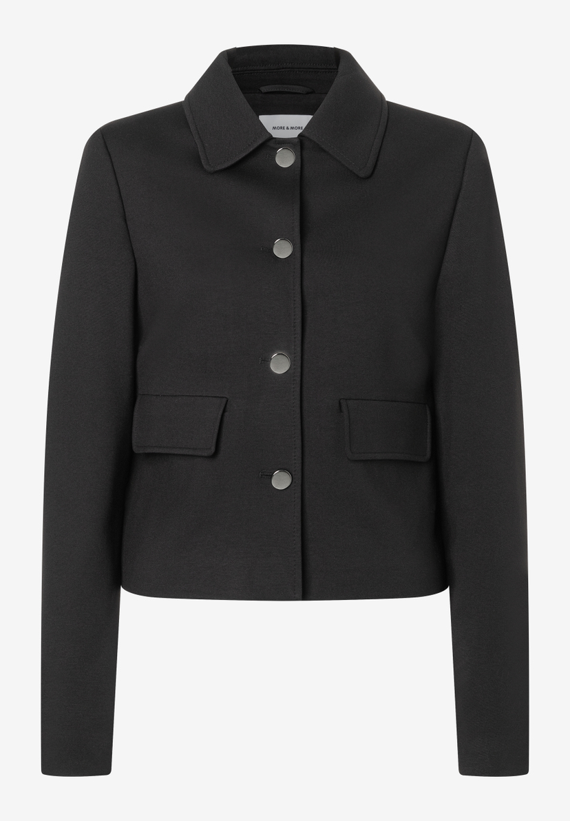 Ein schwarzer MORE & MORE Blazer mit Knopfleiste und zwei kleinen Taschen. Ein schwarzer MORE & MORE Blazer mit Knopfleiste und zwei kleinen Taschen.