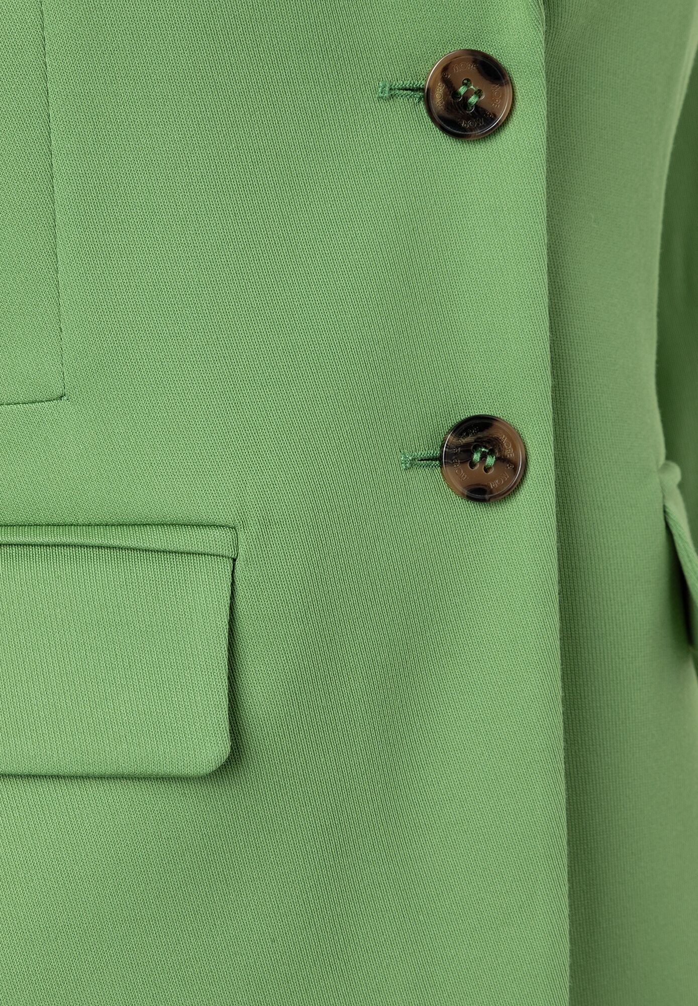 Nahaufnahme eines grünen MORE & MORE Blazers mit Knöpfen und Tasche. Nahaufnahme eines grünen MORE & MORE Blazers mit Knöpfen und Tasche.