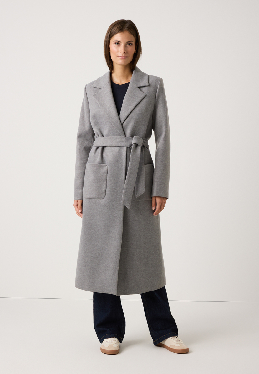 Eine Frau trägt einen grauen MORE & MORE-Mantel mit Bindegürtel. Webware für angenehmen Tragekomfort. Eine Frau trägt einen grauen MORE & MORE-Mantel mit Bindegürtel. Webware für angenehmen Tragekomfort.