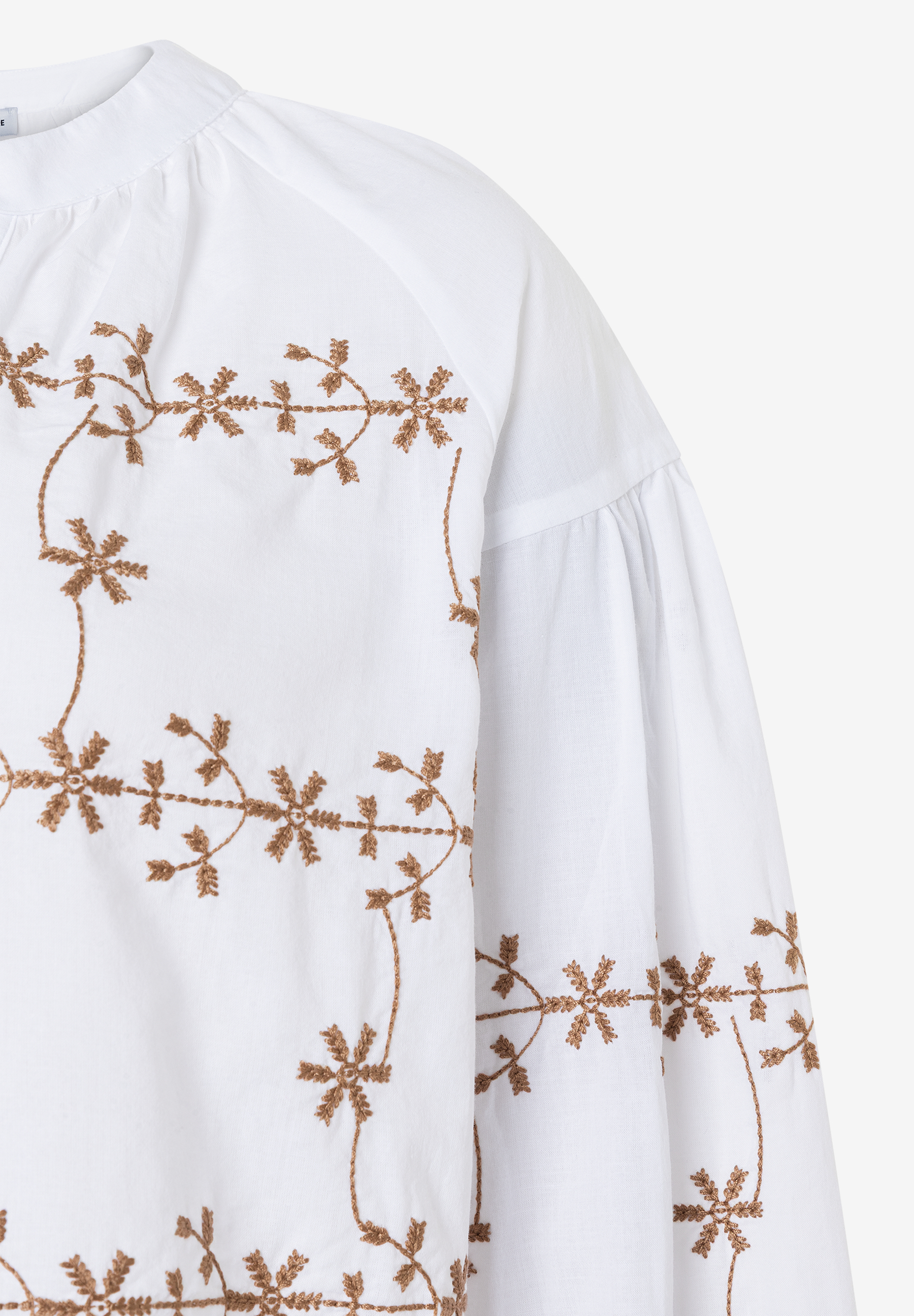 Nahaufnahme einer weißen MORE & MORE Bluse mit floraler Stickerei. Nahaufnahme einer weißen MORE & MORE Bluse mit floraler Stickerei.