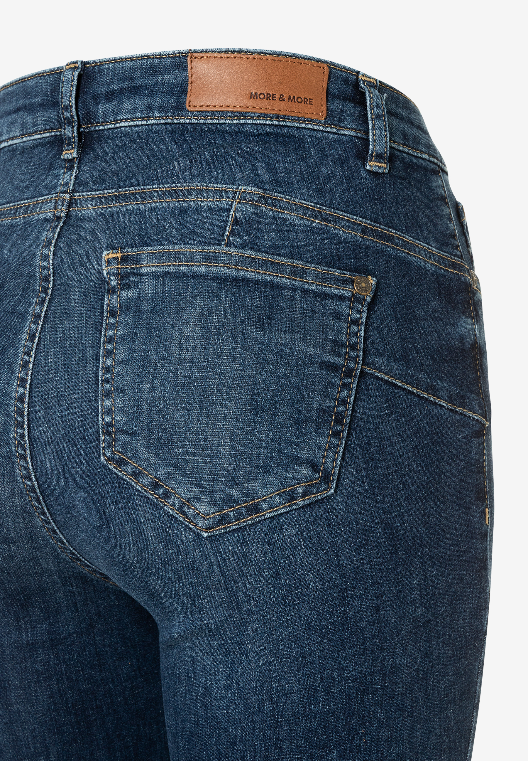 Detailansicht einer MORE & MORE Denim-Jeans mit Gesäßtasche und Lederlabel am Bund. Detailansicht einer MORE & MORE Denim-Jeans mit Gesäßtasche und Lederlabel am Bund.