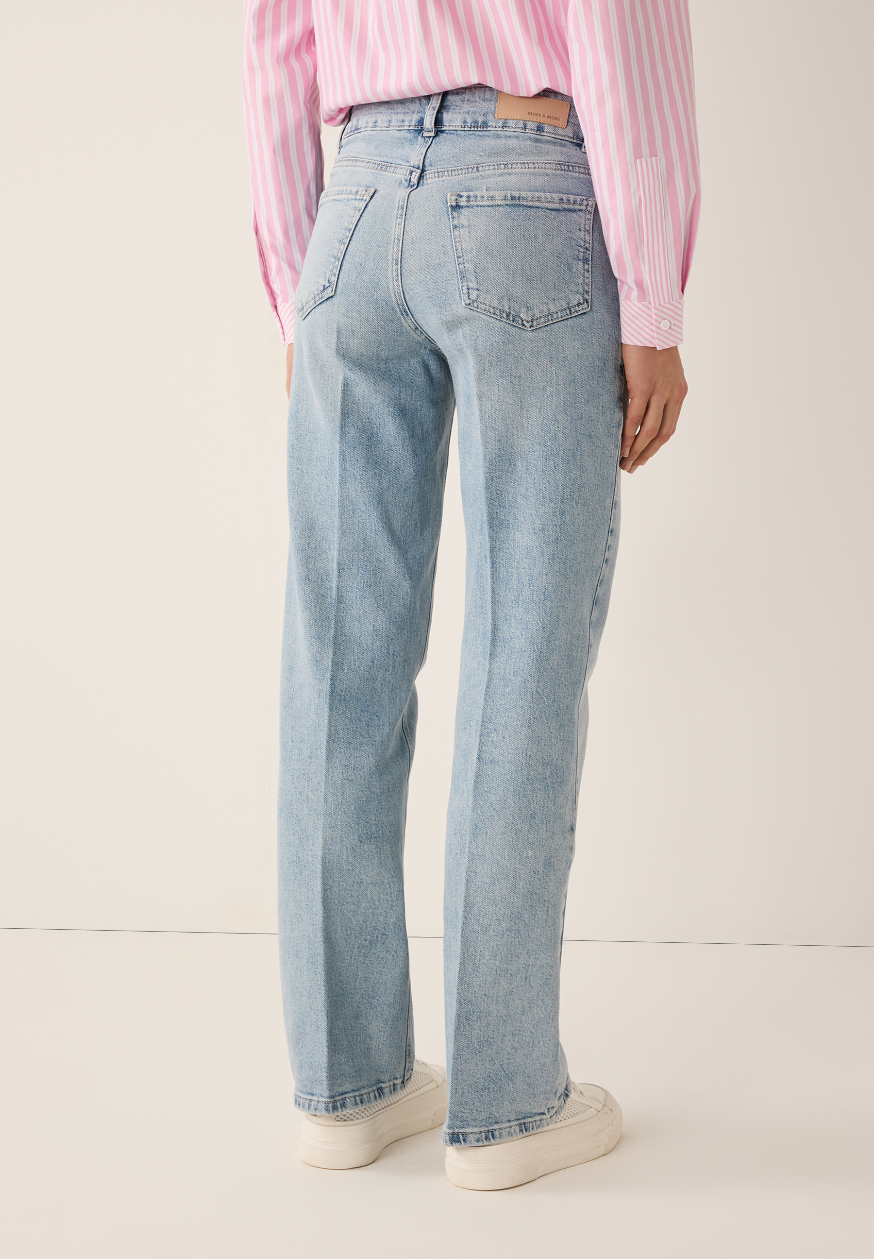 Hinteransicht einer Person in MORE & MORE Jeans, einem gestreiften Hemd und weißen Schuhen. Hinteransicht einer Person in MORE & MORE Jeans, einem gestreiften Hemd und weißen Schuhen.