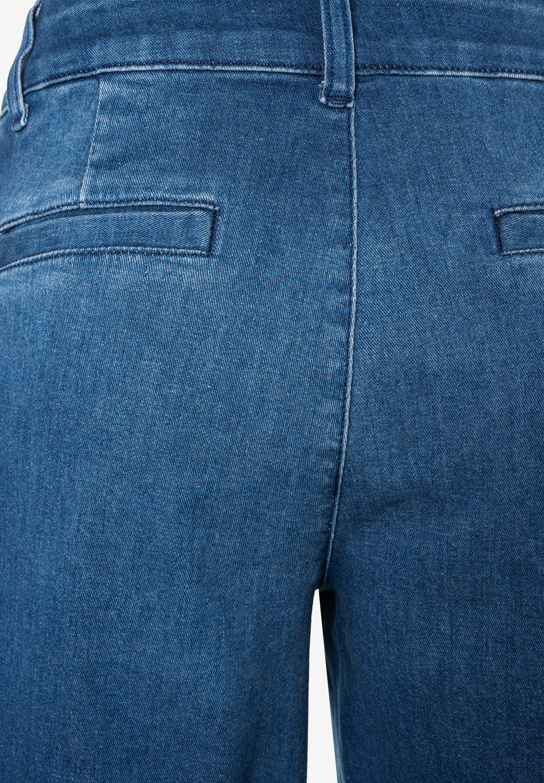 Nahaufnahme der Rückseite einer blauen MORE & MORE Jeans aus robustem Denim mit Stretch und Gesäßtaschen. Nahaufnahme der Rückseite einer blauen MORE & MORE Jeans aus robustem Denim mit Stretch und Gesäßtaschen.