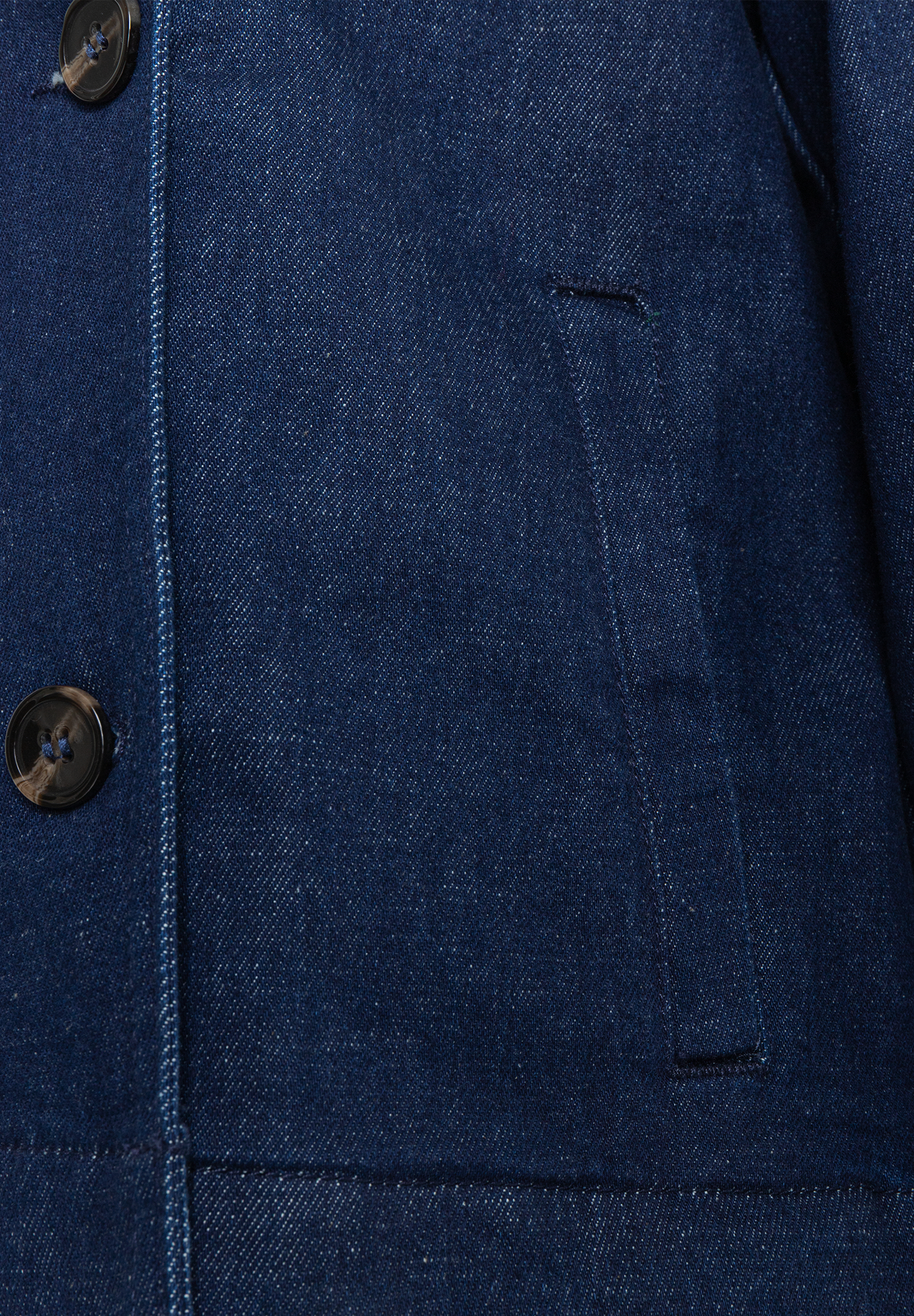 Nahaufnahme einer robusten, blauen MORE & MORE Jeansjacke mit Knopfleiste und aufgesetzter Tasche. Nahaufnahme einer robusten, blauen MORE & MORE Jeansjacke mit Knopfleiste und aufgesetzter Tasche.