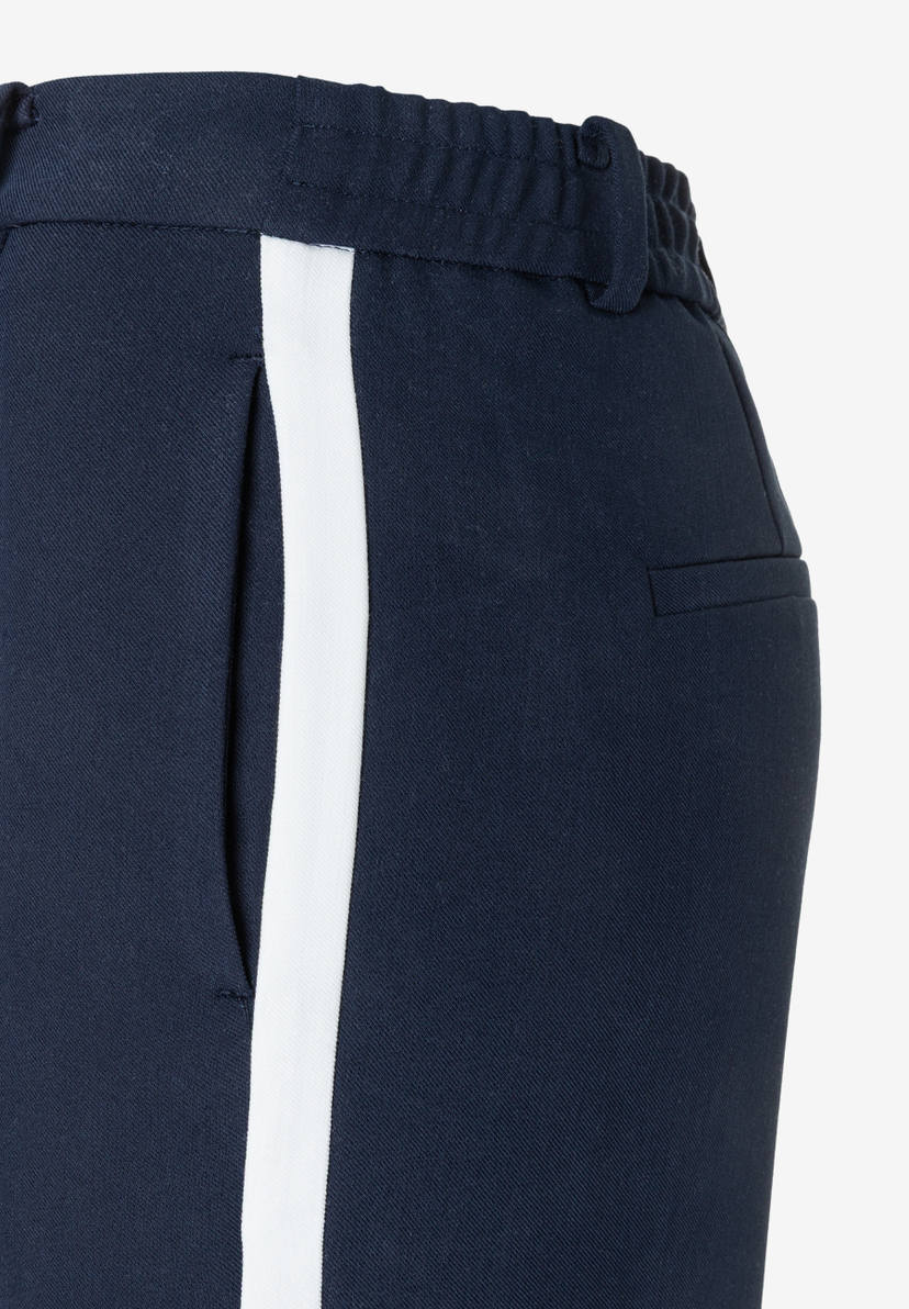 Detailaufnahme einer MORE & MORE Hose, dunkelblau mit weißem Seitenstreifen, Webware und fließend-angenehmer Tragekomfort. Detailaufnahme einer MORE & MORE Hose, dunkelblau mit weißem Seitenstreifen, Webware und fließend-angenehmer Tragekomfort.