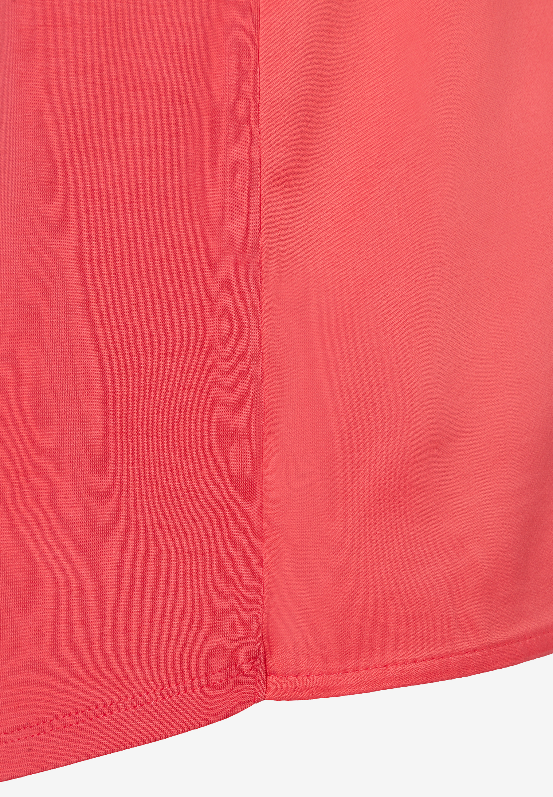 Nahaufnahme eines korallenroten MORE & MORE Oberteils aus Jersey und Satin mit glänzender Optik. Nahaufnahme eines korallenroten MORE & MORE Oberteils aus Jersey und Satin mit glänzender Optik.