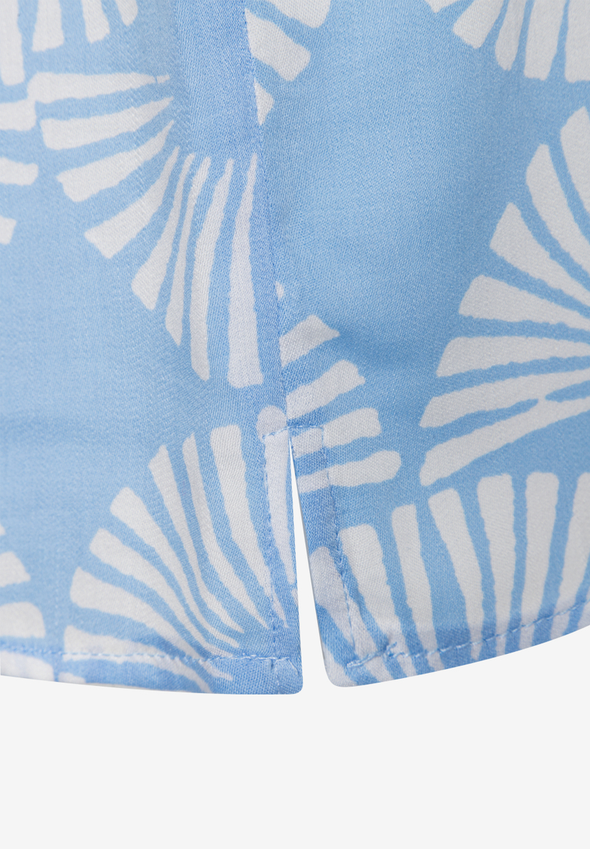 Nahaufnahme einer MORE & MORE Bluse mit blau-weißem Muster und seitlichem Saumschlitz. Nahaufnahme einer MORE & MORE Bluse mit blau-weißem Muster und seitlichem Saumschlitz.