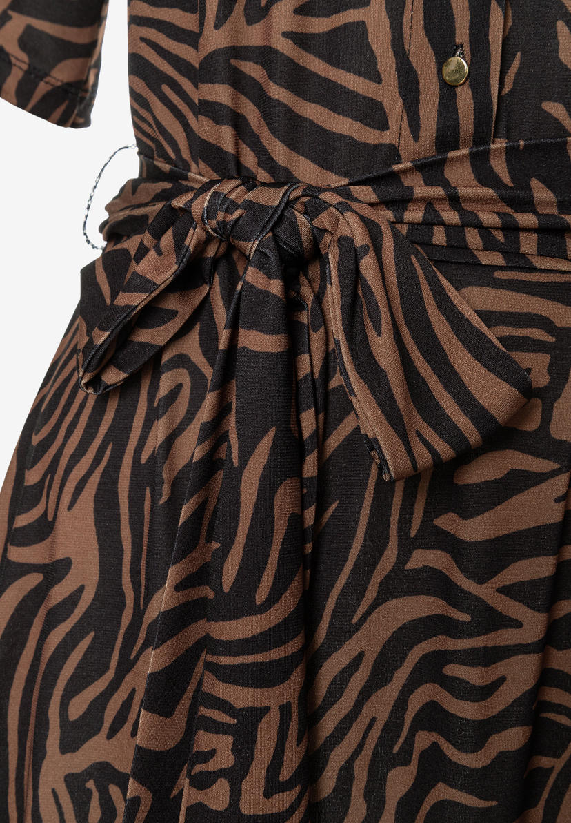 Detailaufnahme eines MORE & MORE Oberteils mit Zebra-Muster und Stoffgürtel. Detailaufnahme eines MORE & MORE Oberteils mit Zebra-Muster und Stoffgürtel.
