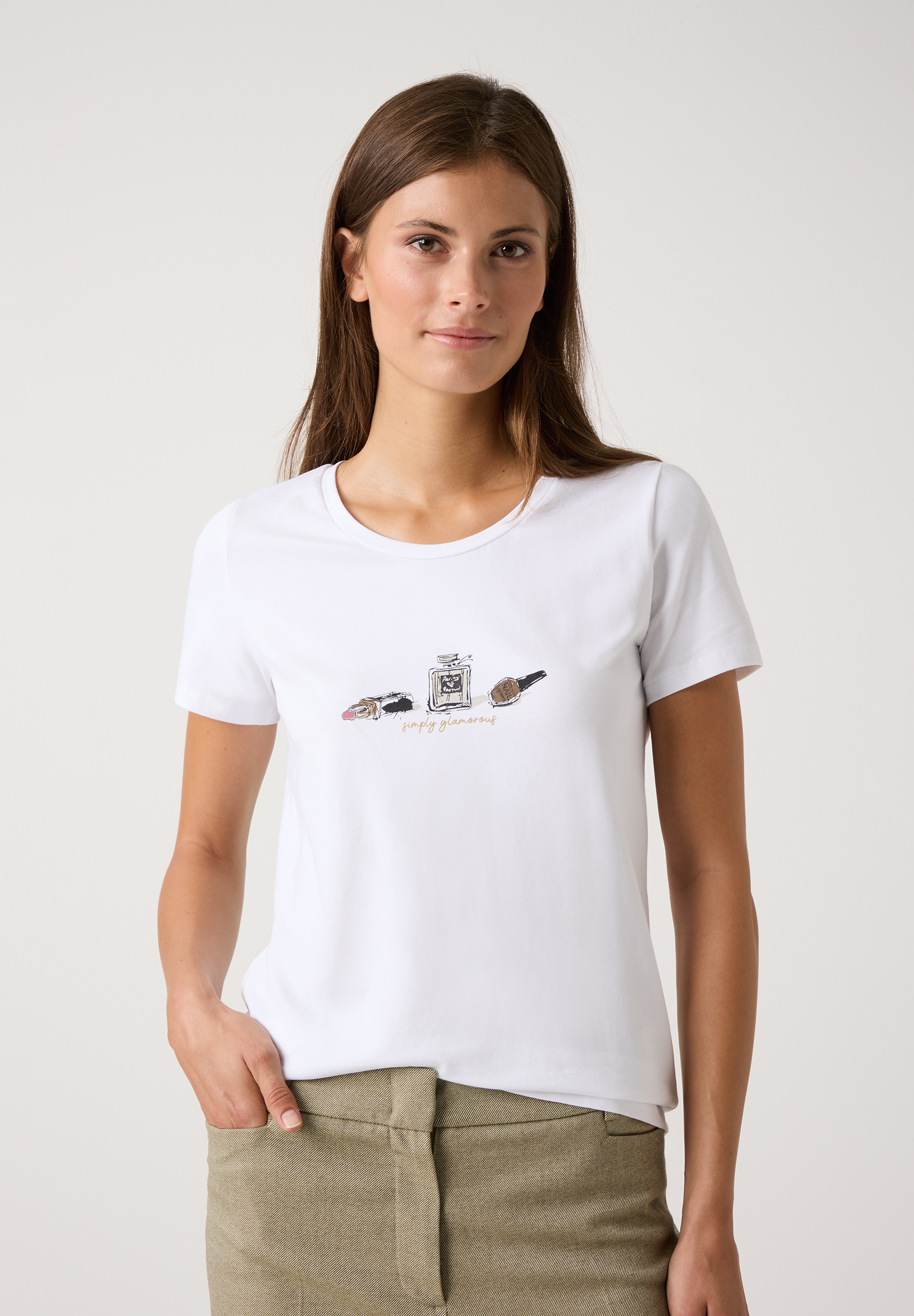 Eine Frau trägt ein weißes T-Shirt von MORE & MORE mit einem Aufdruck von Kosmetikartikeln. Eine Frau trägt ein weißes T-Shirt von MORE & MORE mit einem Aufdruck von Kosmetikartikeln.