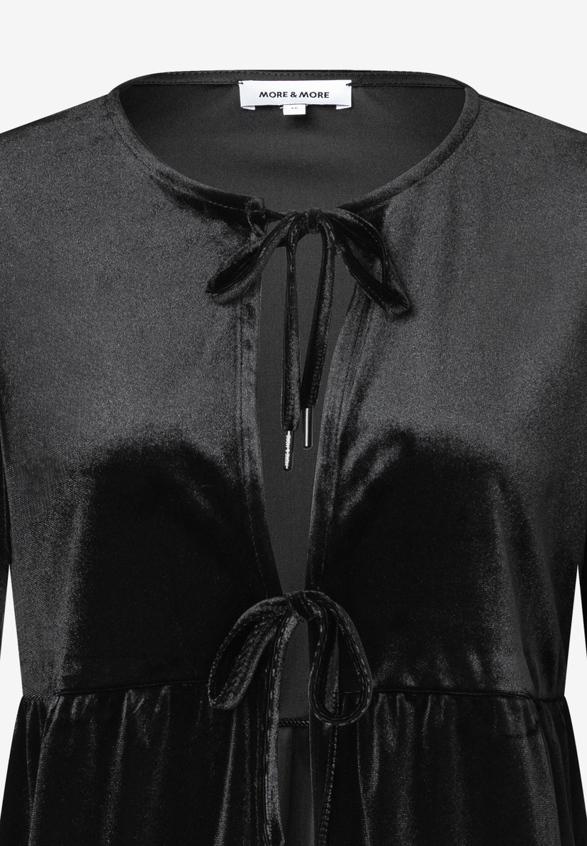 Ein schwarzes Samt-Top von MORE & MORE mit Bindebändern am Ausschnitt. Ein schwarzes Samt-Top von MORE & MORE mit Bindebändern am Ausschnitt.