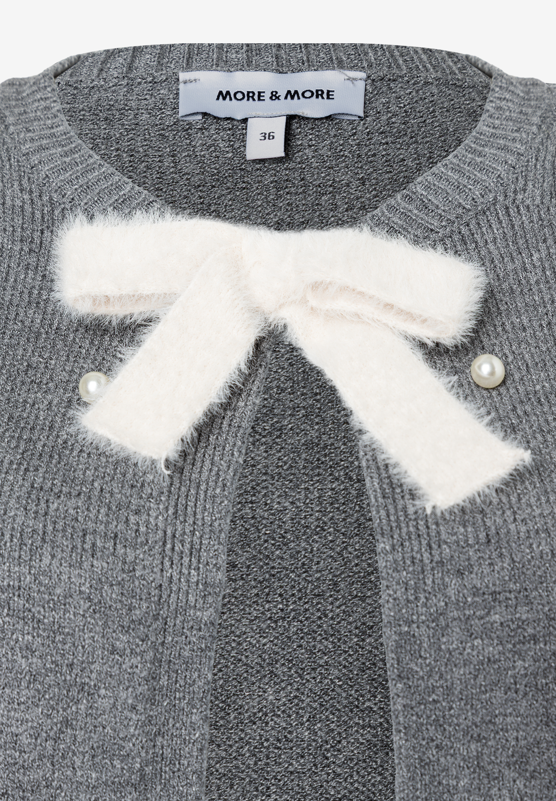 Detailaufnahme einer grauen MORE & MORE Strickjacke mit Schleife und Perlenknöpfen. Detailaufnahme einer grauen MORE & MORE Strickjacke mit Schleife und Perlenknöpfen.