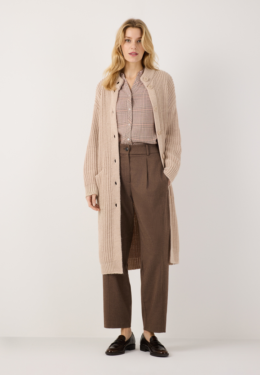 MORE & MORE Hose & Cardigan: Eine junge Frau trägt eine beigefarbene, locker gestrickte Strickjacke und eine braune MORE & MORE Jeans. MORE & MORE Hose & Cardigan: Eine junge Frau trägt eine beigefarbene, locker gestrickte Strickjacke und eine braune MORE & MORE Jeans.