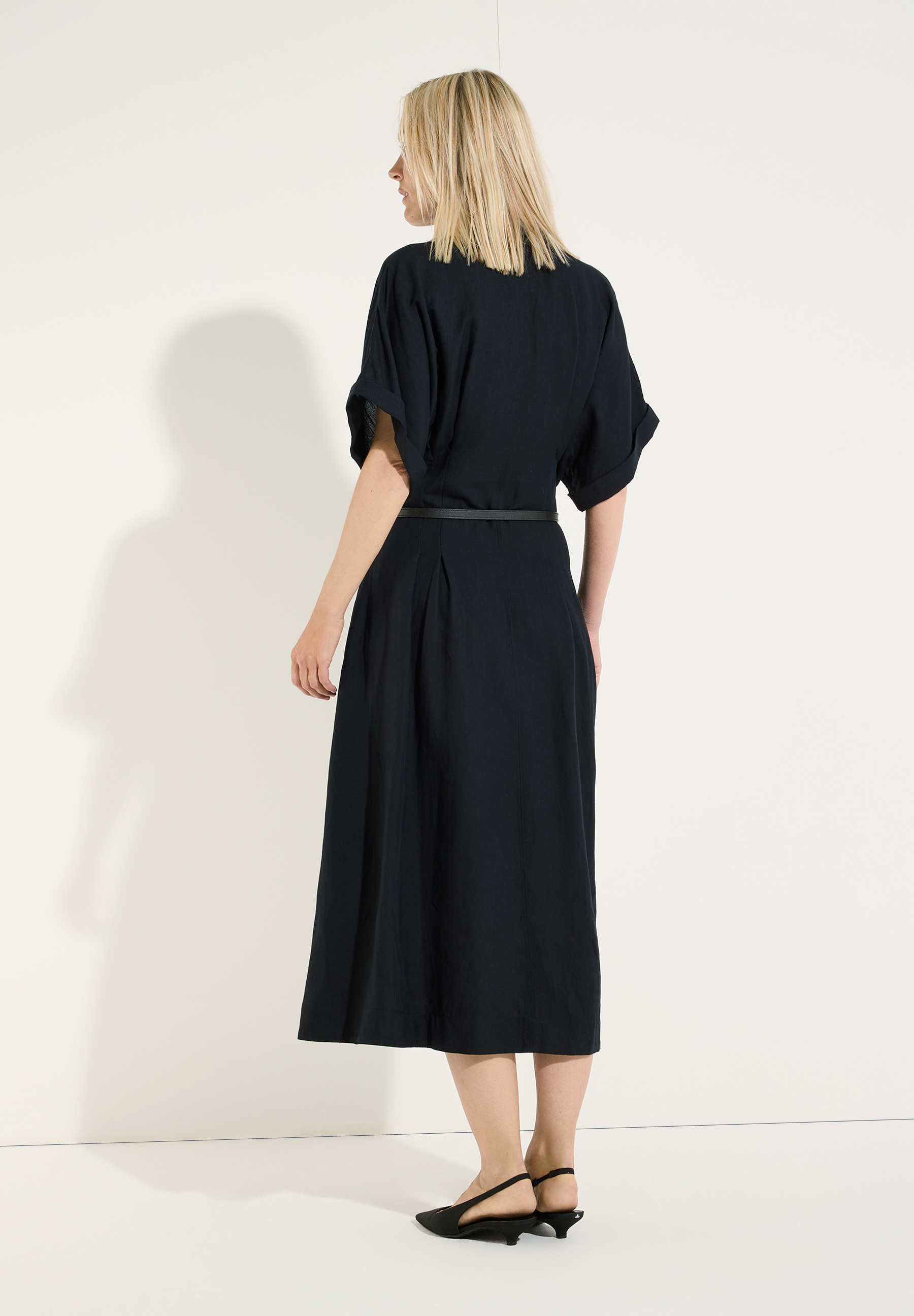 MORE & MORE Kleid in Schwarz, im Rückenansicht, mit kurzen, umgeschlagenen Ärmeln und Gürtel, bis zu den Waden. MORE & MORE Kleid in Schwarz, im Rückenansicht, mit kurzen, umgeschlagenen Ärmeln und Gürtel, bis zu den Waden.