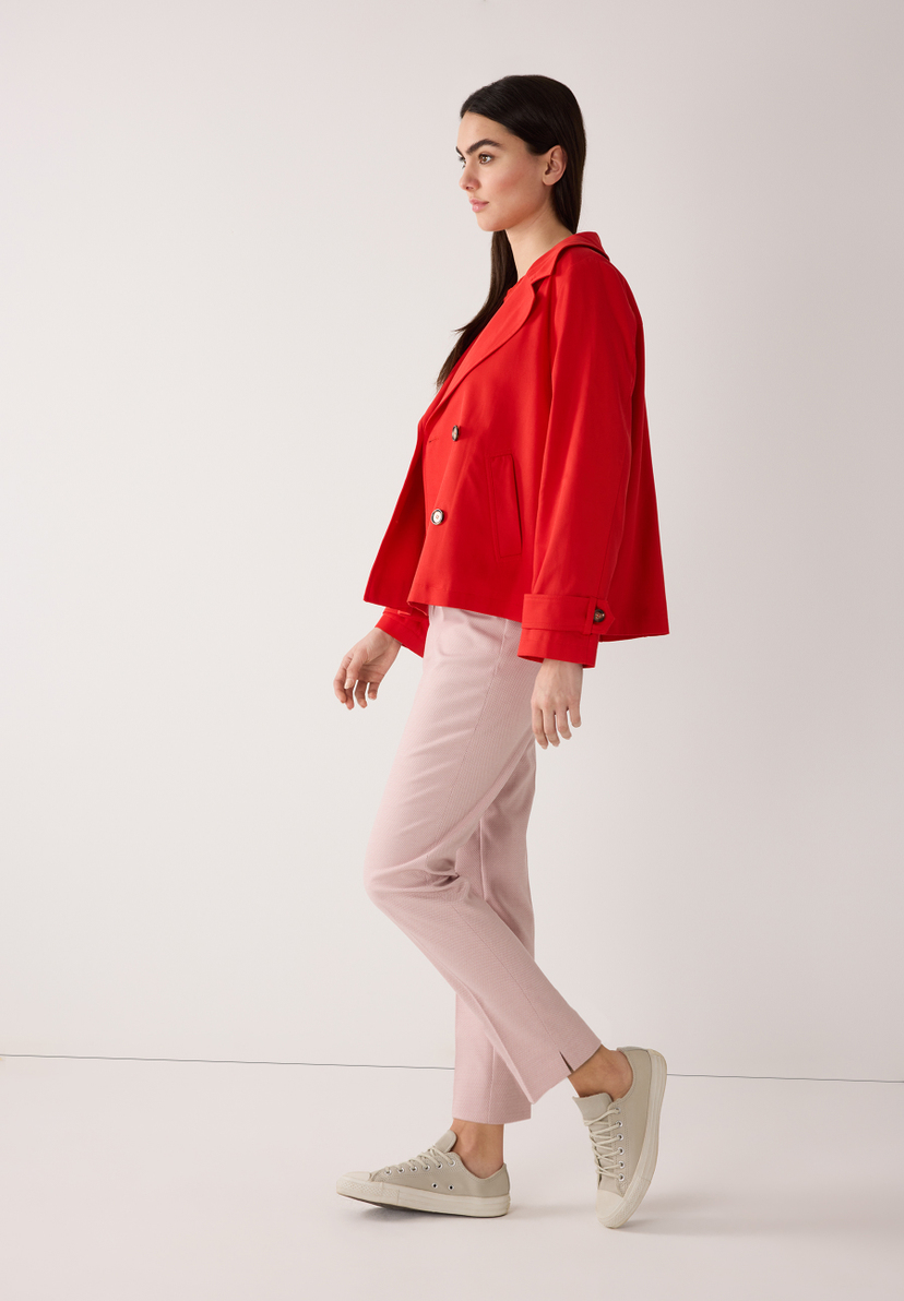 Eine Frau in roter MORE & MORE Jacke aus Twill mit angenehmem Tragekomfort, kombinierrt mit rosafarbener Hose und Sneakern. Eine Frau in roter MORE & MORE Jacke aus Twill mit angenehmem Tragekomfort, kombinierrt mit rosafarbener Hose und Sneakern.