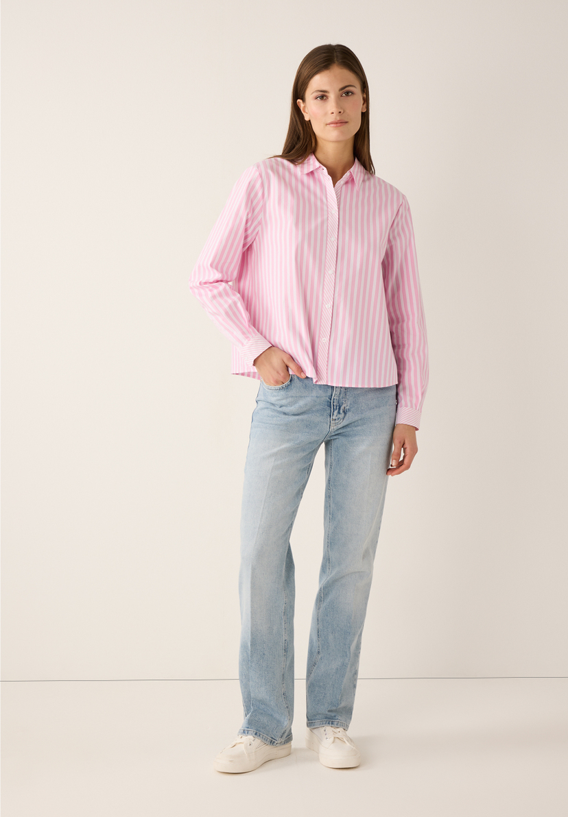Eine Frau in MORE & MORE Jeans und gestreifter Bluse. Eine Frau in MORE & MORE Jeans und gestreifter Bluse.